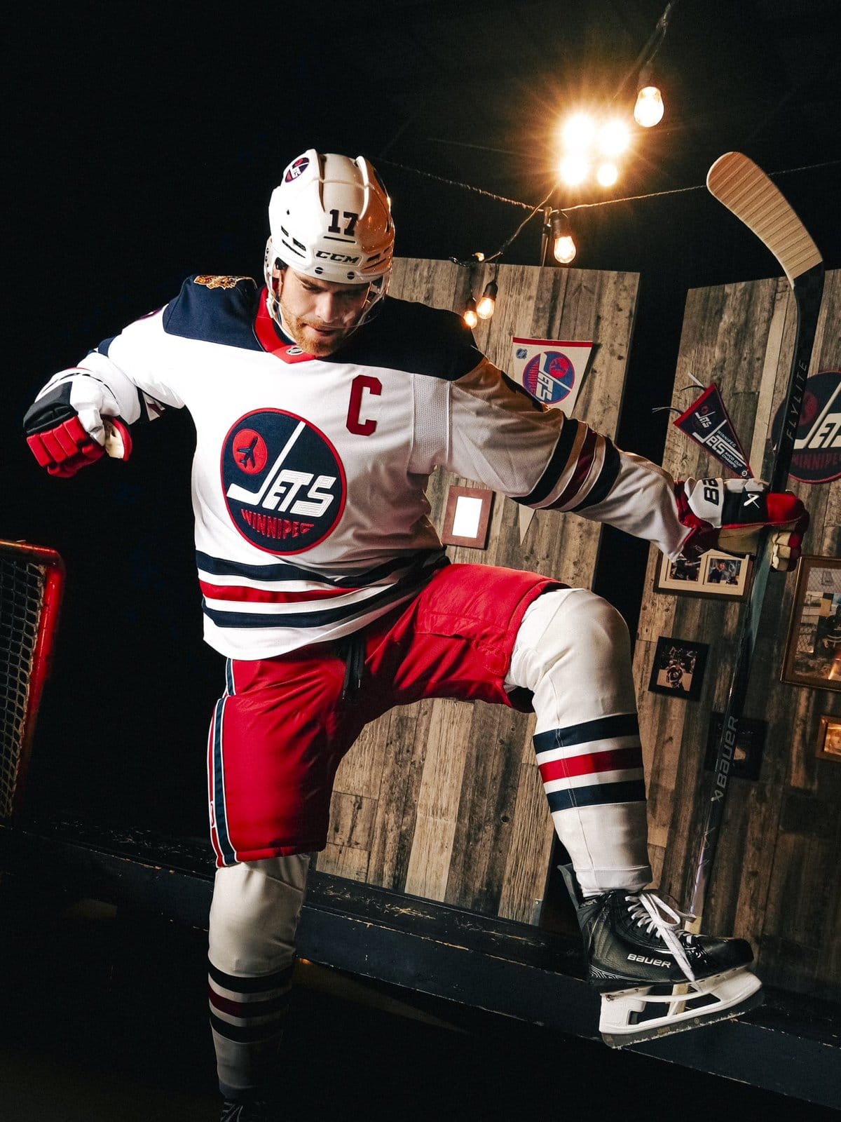 Jets captain Adam Lowry in the white 2026 Heritage Classic sweater, red pants and navy, red and white striped socks