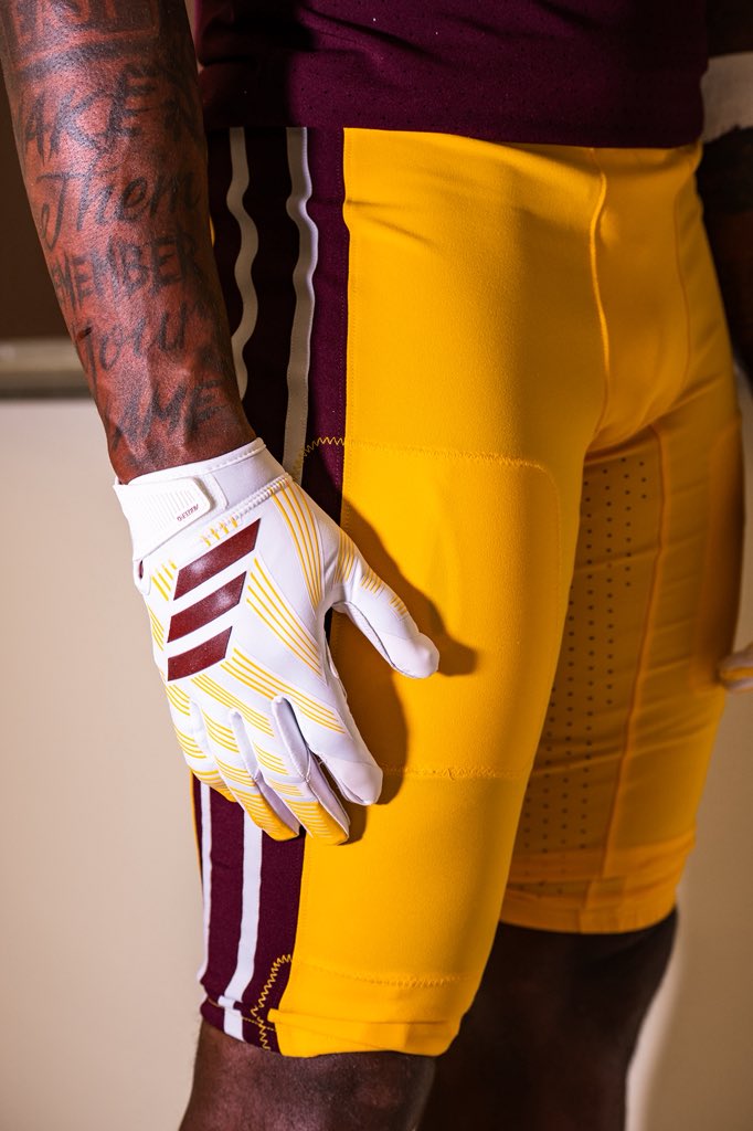 Detail of the Arizona State 2026 throwback uniform showing the gold pants with the maroon and white leg stripe next to the maroon jersey striping, and a white adidas glove with maroon three stripes