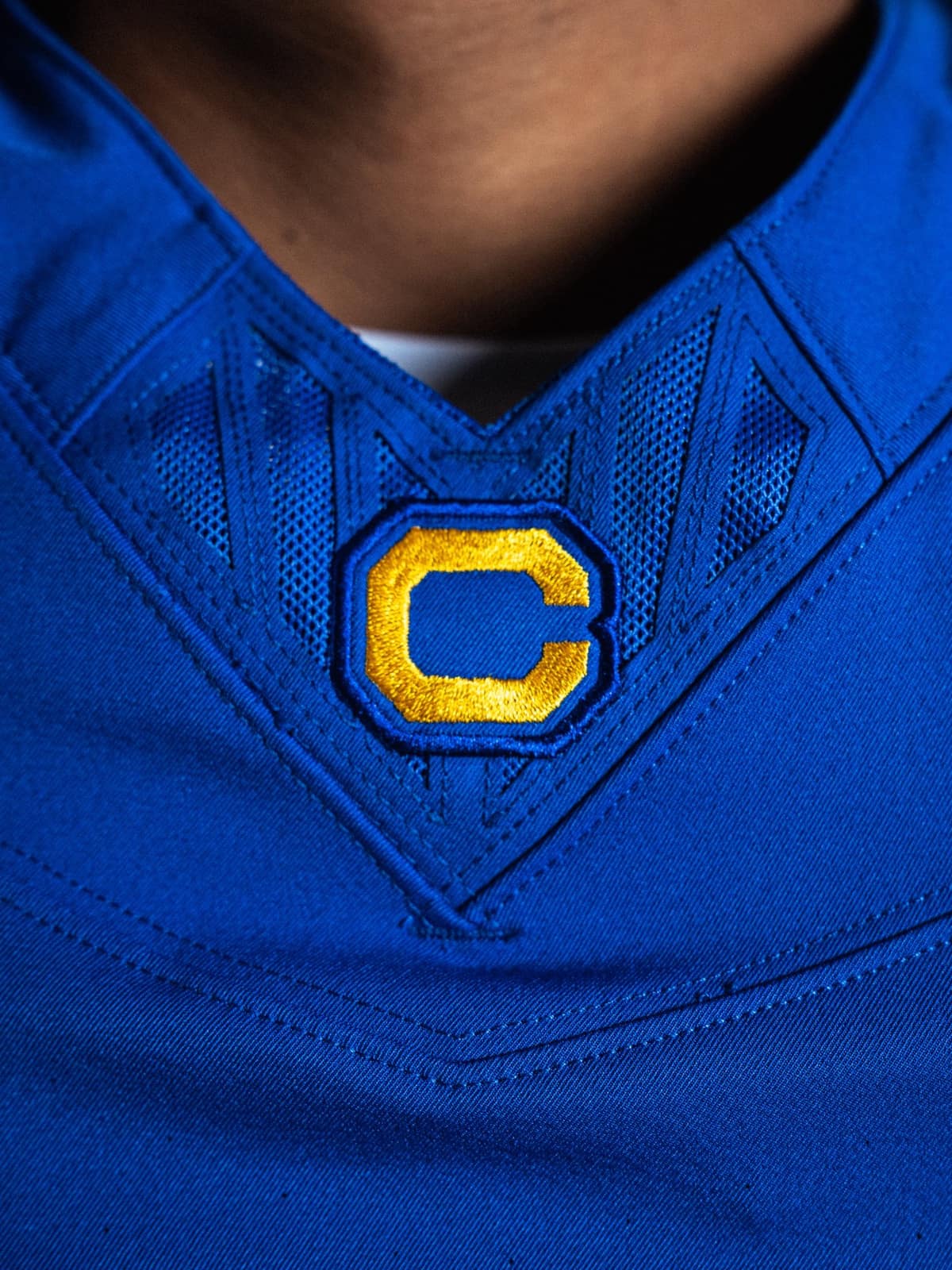 Close-up of the gold block C embroidered at the collar of the Cal Joe Roth throwback jersey