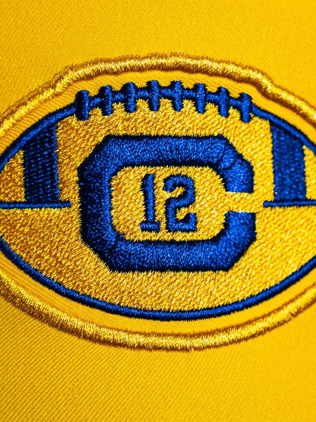 The Joe Roth memorial patch on the Cal 2026 throwback uniform, a gold football outline containing a blue block C with the number 12 inside it