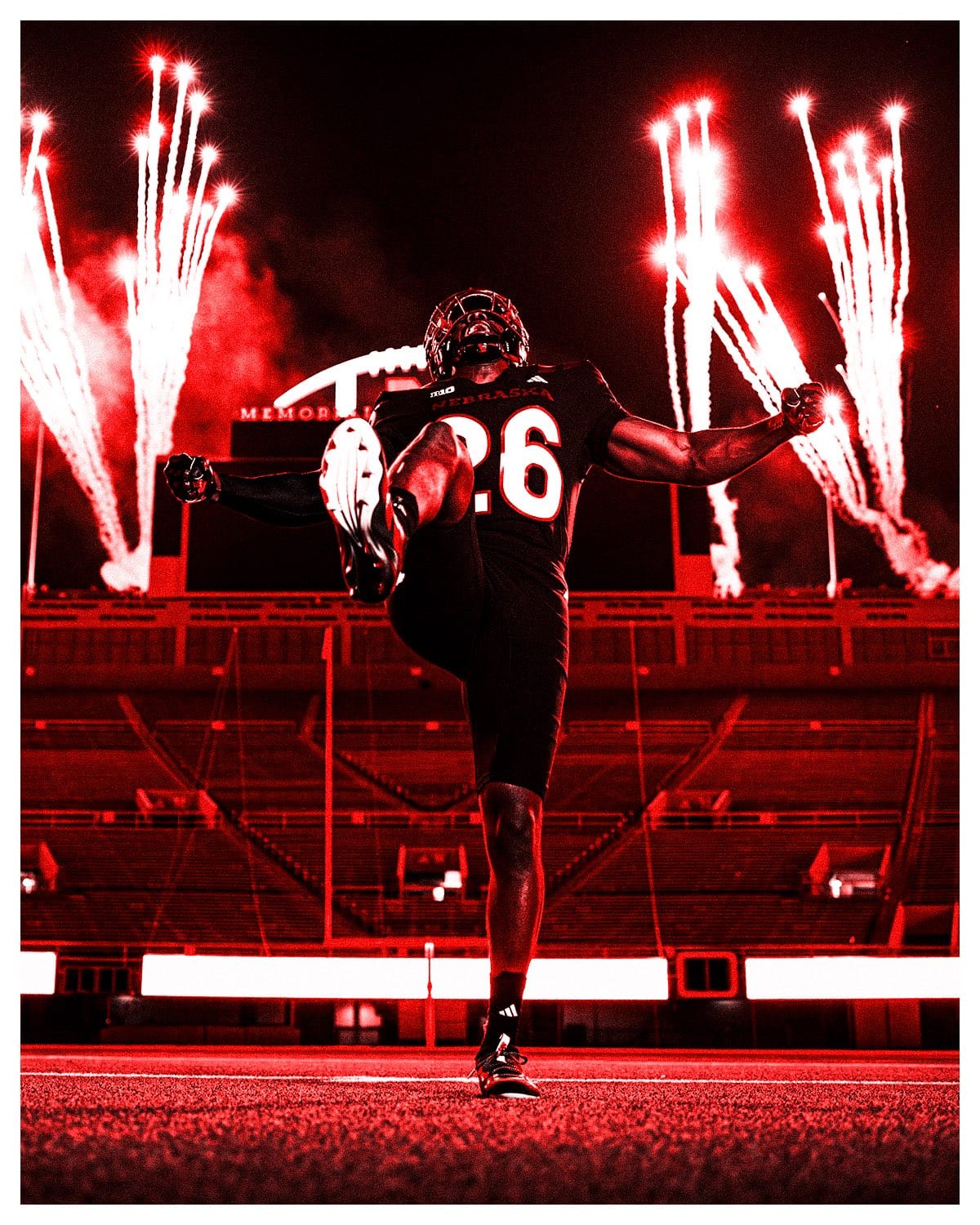 Nebraska player in the 2026 blackout uniform on the Memorial Stadium field with fireworks going off behind him