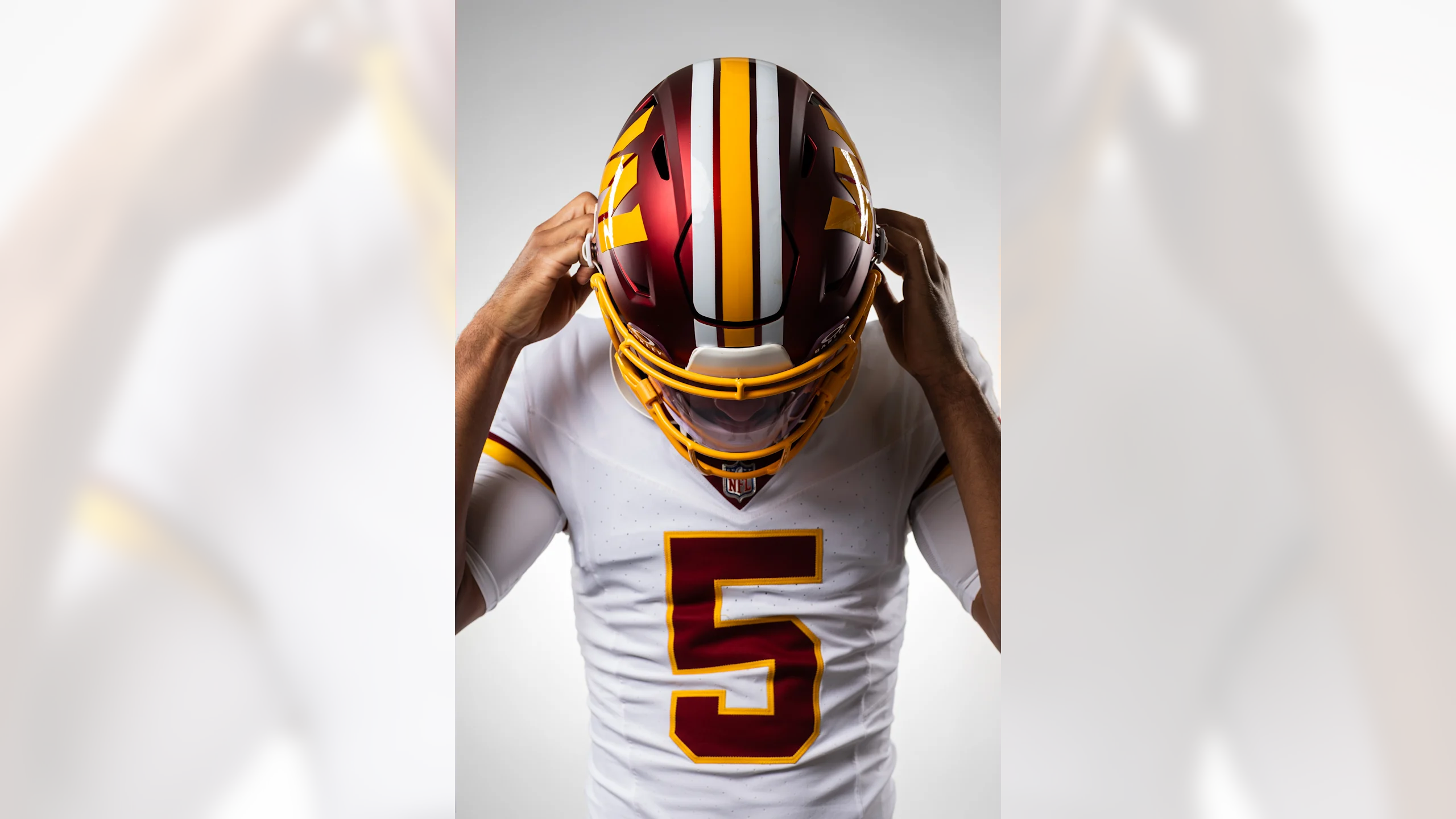 Jayden Daniels putting on throwback Washington helmet