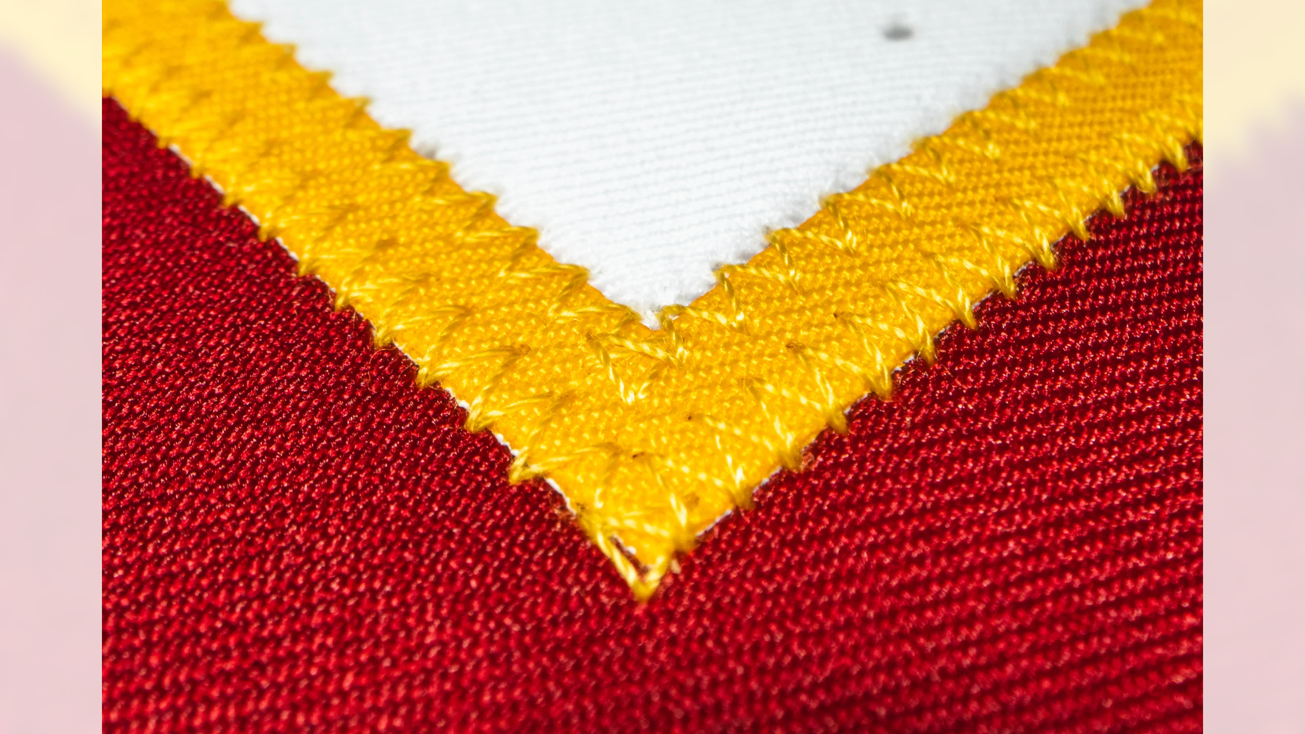 Macro close-up of Washington Commanders jersey burgundy and gold chevron stitching