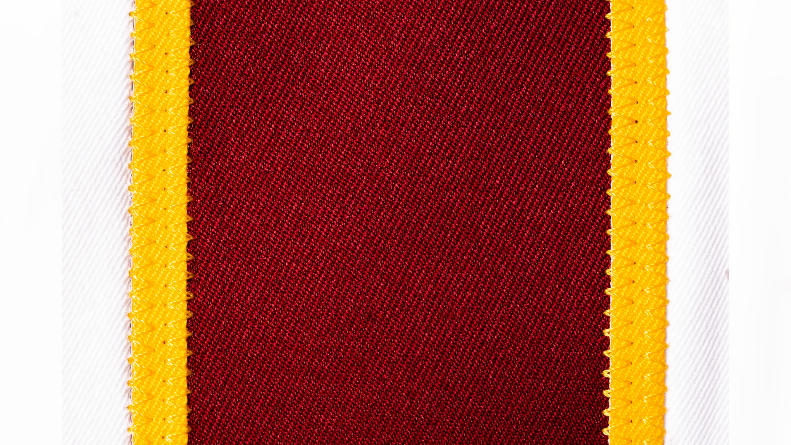 Macro close-up of Washington Commanders burgundy pants stripe with gold trim