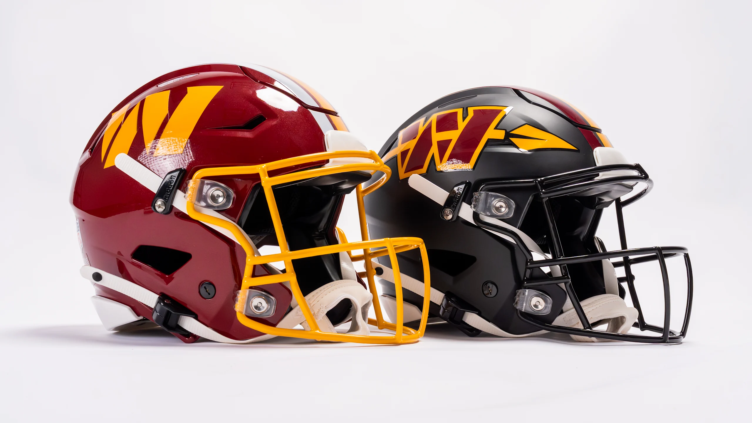 Washington Commanders 2026 primary burgundy helmet with gold facemask and black Hail Raiser alternate helmet side by side