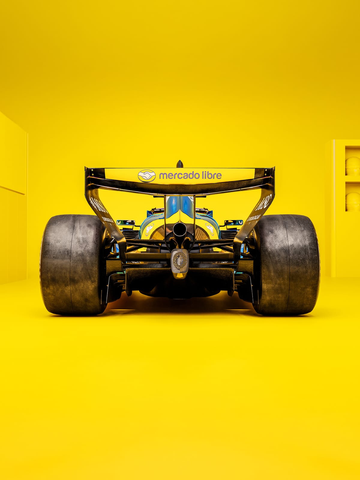Alpine F1 Miami Grand Prix 2026 Argentinian twist rear view of Franco Colapinto number 43 car on yellow Mercado Libre background showcasing the rear wing branding