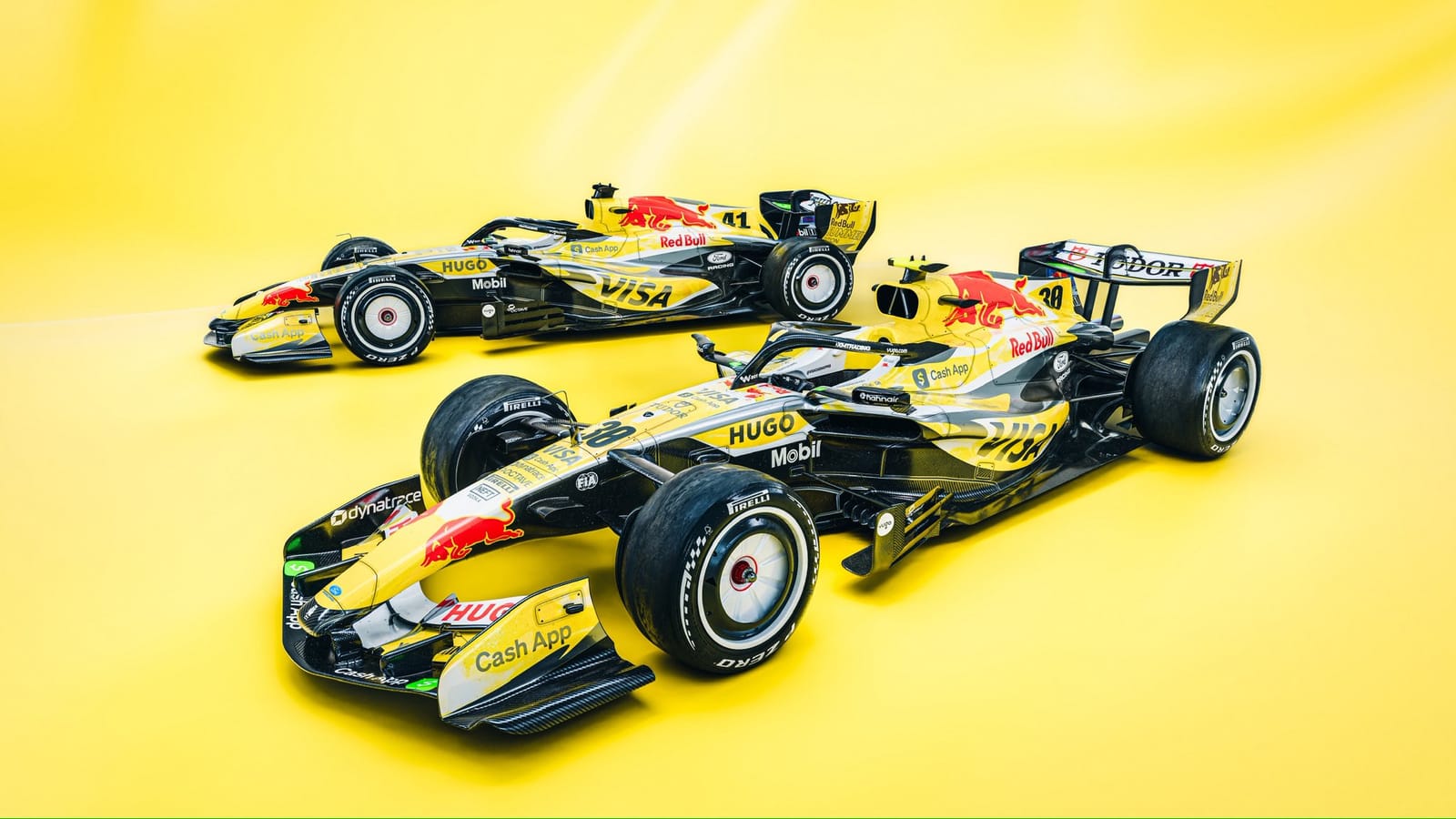 Visa Cash App RB Summer Edition Miami GP 2026 yellow livery two-car group shot of Liam Lawson and Arvid Lindblad's cars together on a yellow studio background showing both VCARB chassis fully repainted in deep summer-sun yellow with Red Bull Hugo and Visa branding