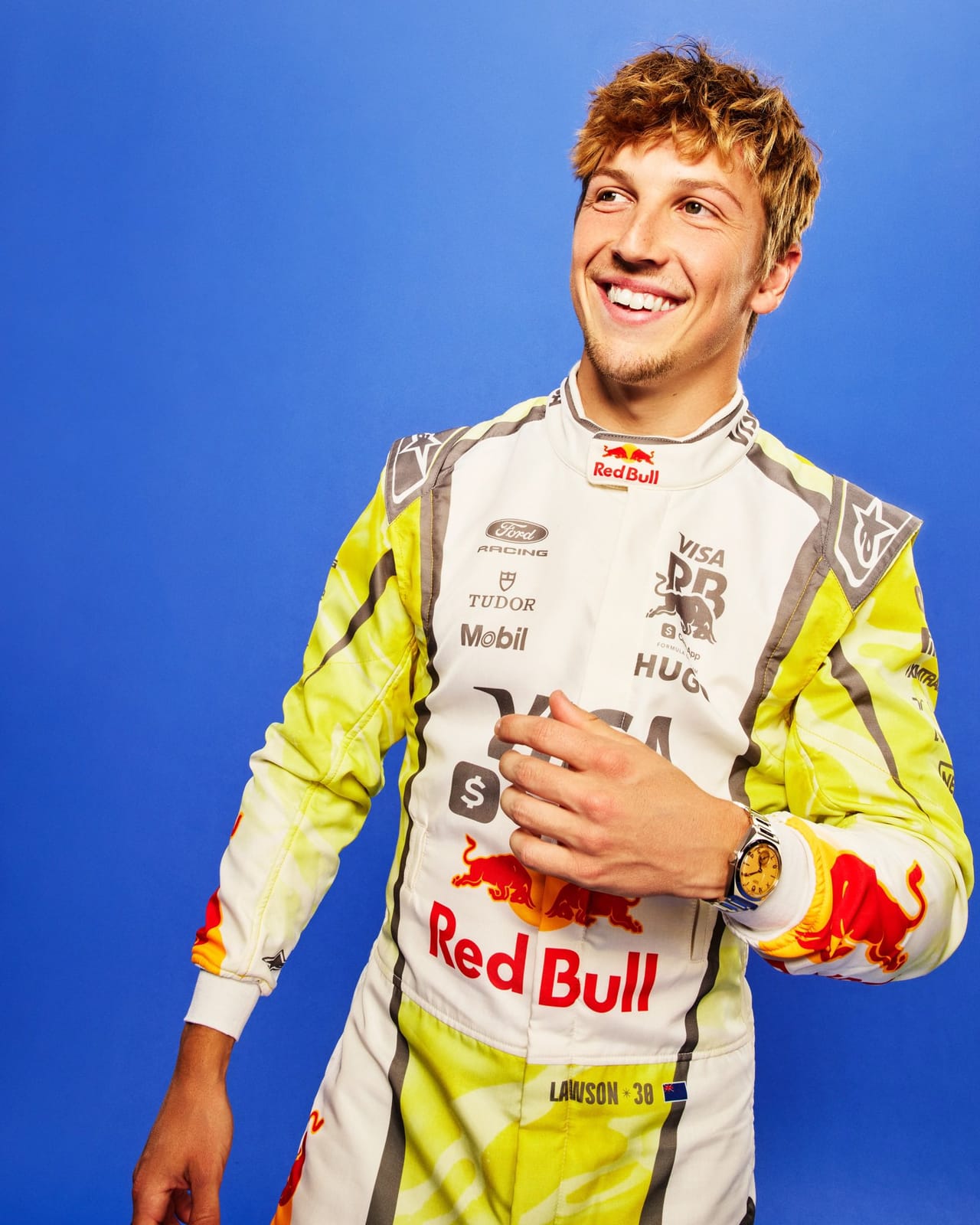 Visa Cash App RB Summer Edition Miami GP 2026 driver Liam Lawson in yellow camouflage race suit with white shoulders and Red Bull Visa Cash App Tudor and Hugo sponsor branding photographed on a deep blue studio background with the number 30 visible on the leg
