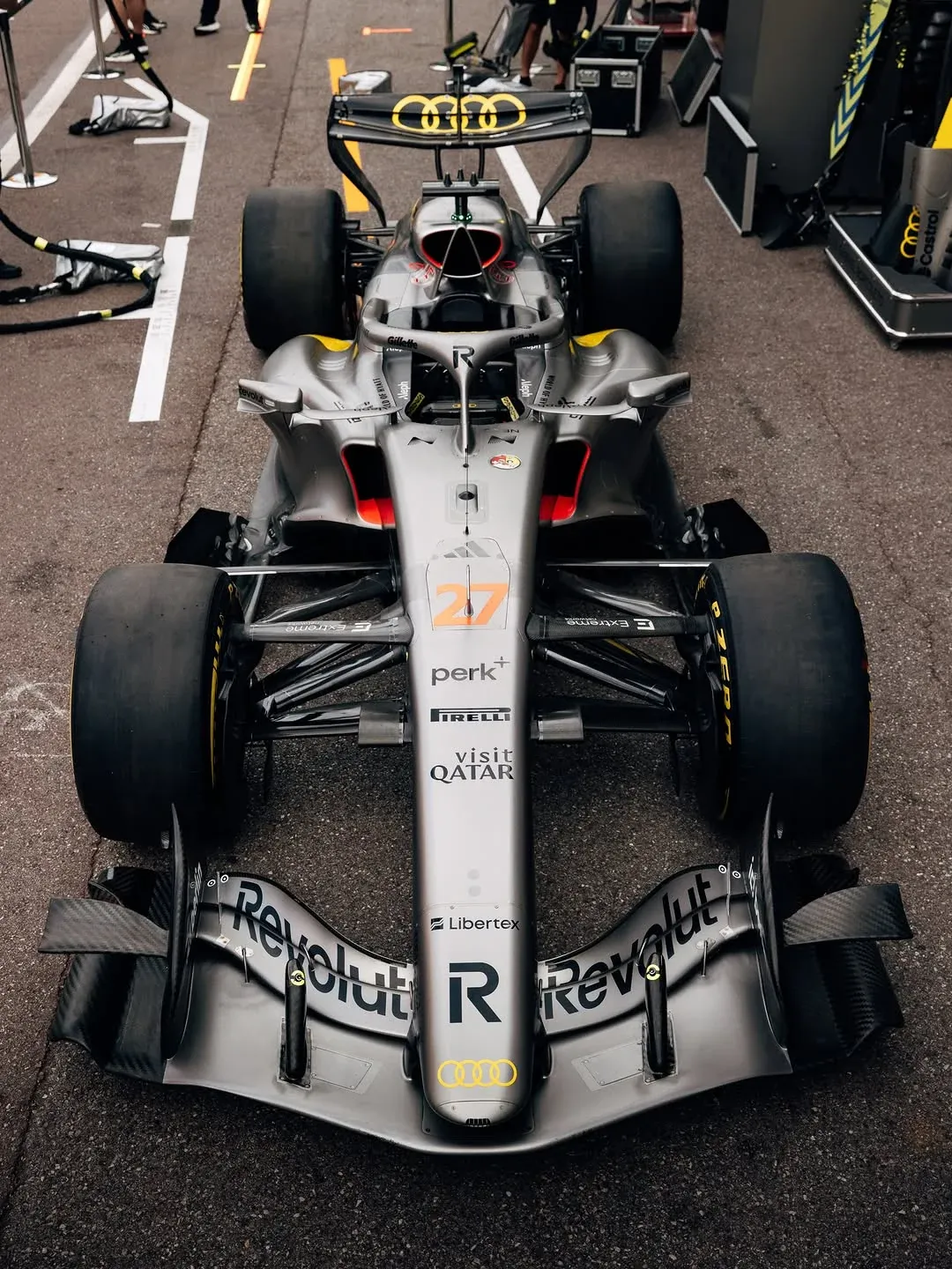 Audi F1 2026 Monaco Grand Prix car front three-quarter view showing the titanium-silver carbon body with the Revolut R wordmark on the nose as the base for the Tazio Nuvolari yellow tribute Monaco livery