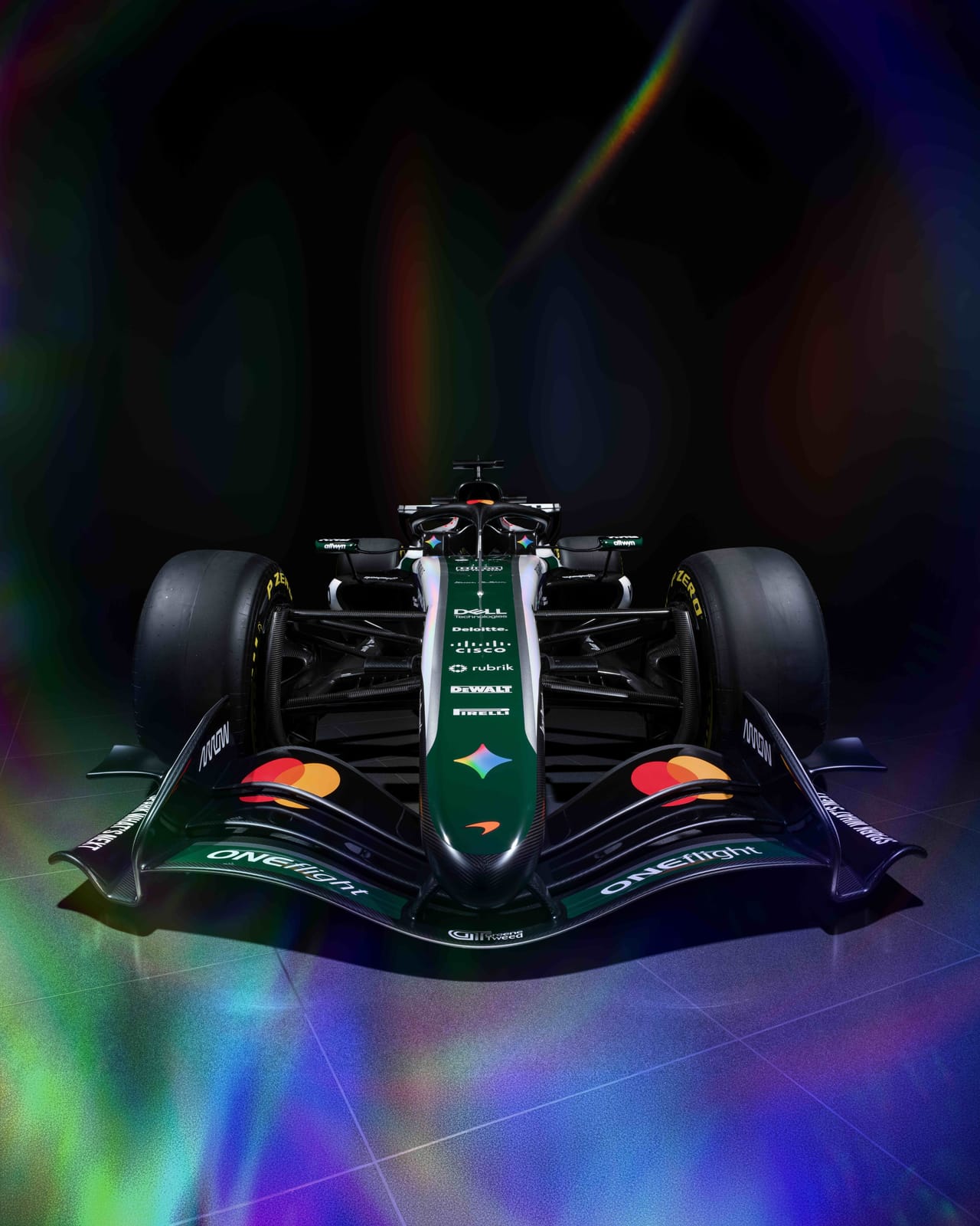 McLaren MCL40 2026 British Grand Prix heritage livery head-on front view showing the green nose and front wing, the white central spine, the Google Gemini four-color gem logo, the Mastercard and ONElight branding, and the British Racing Green floor edges