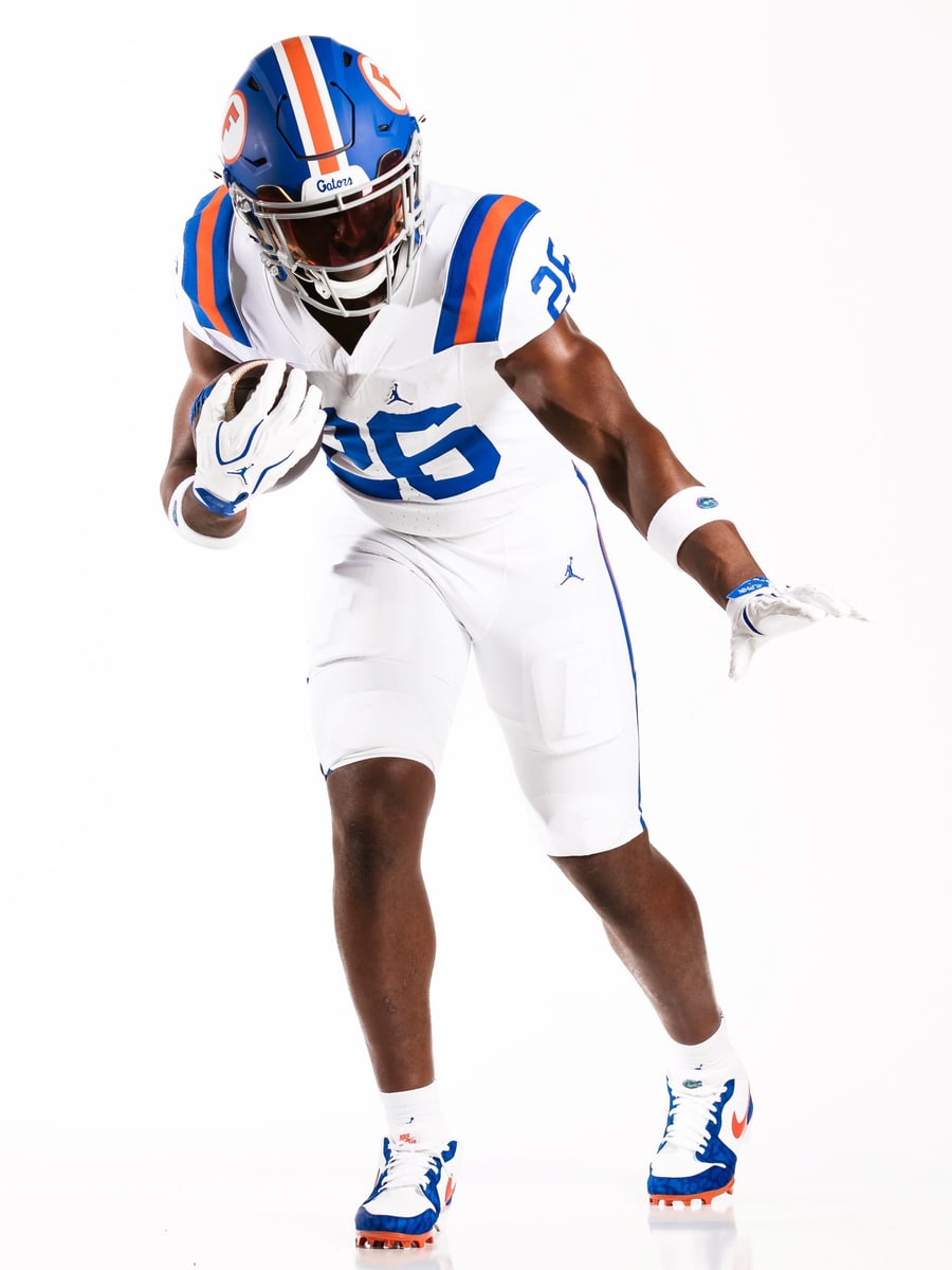 Full front view of the Florida Gators 2026 throwback uniform, white jersey with royal blue numbers and blue and orange shoulder stripes over white pants