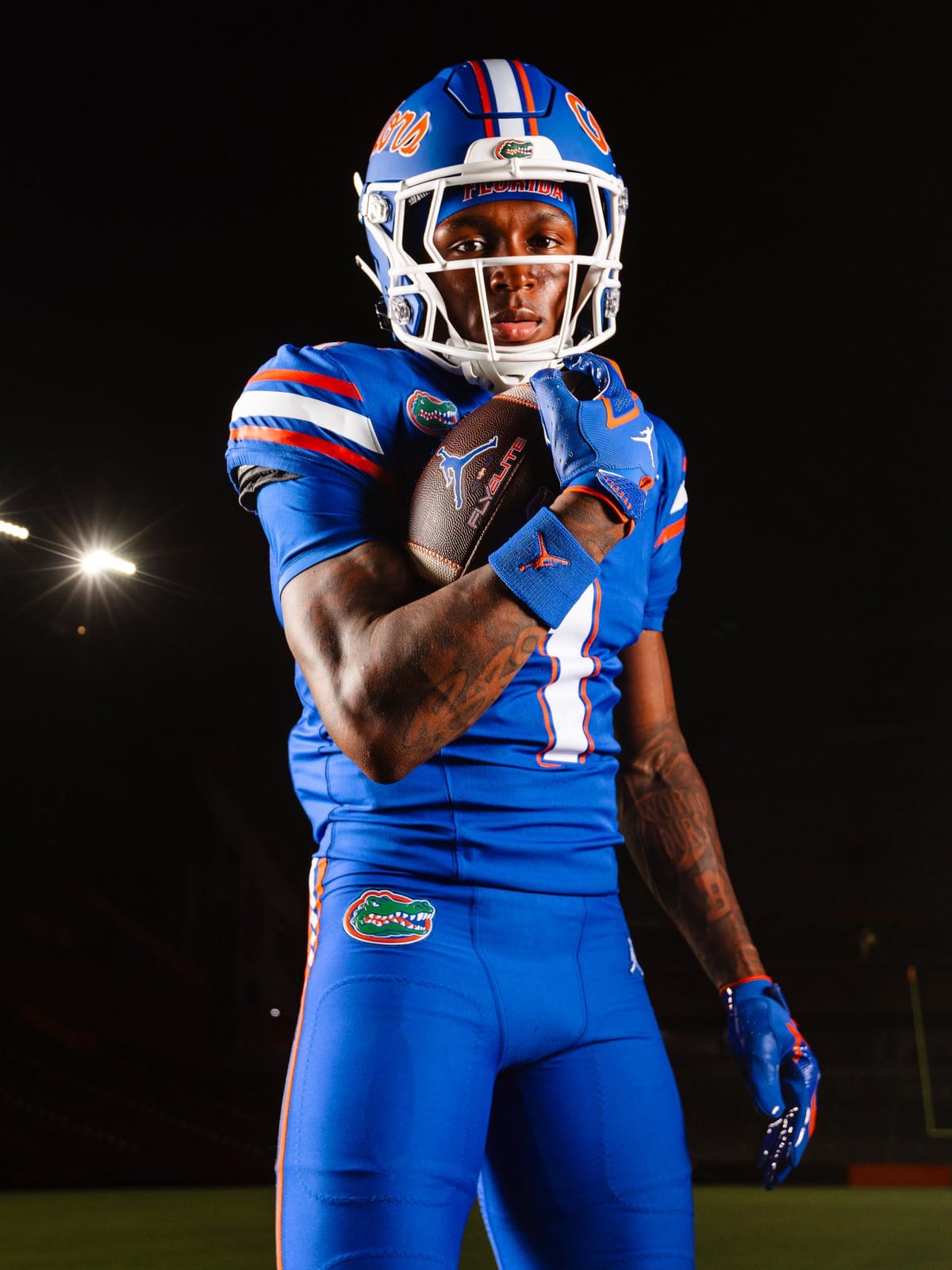 Detail of the Florida Gators all-blue uniform showing the orange and white shoulder striping, the Gator head chest patch, and the white number outlined in orange