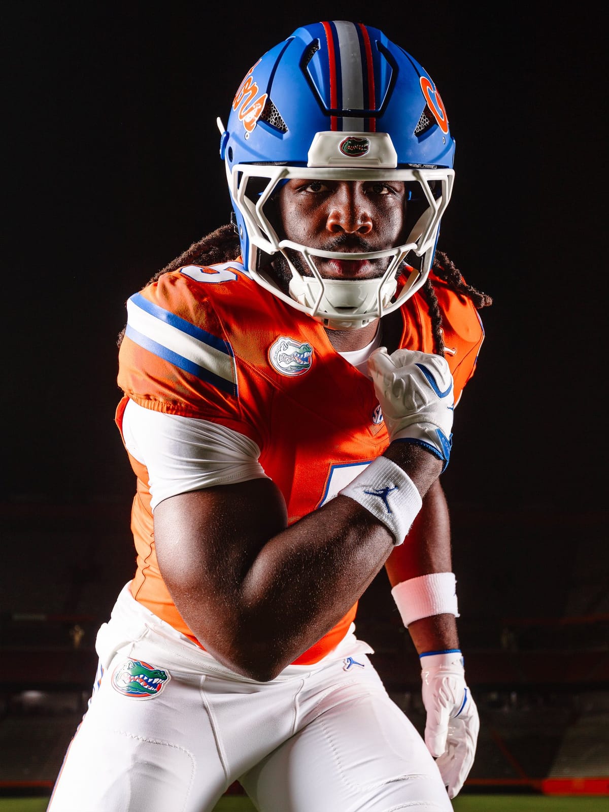 Florida Gators orange jersey showing the blue and white shoulder striping, the Gator head chest patch, and white pants with the Gator head logo