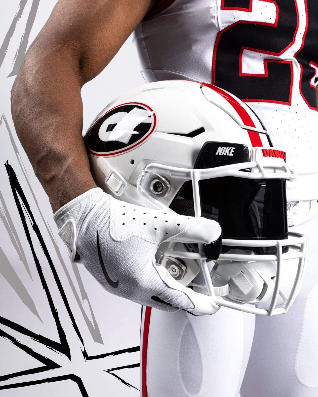 Close-up of the Georgia Bulldogs 2026 white football helmet with the red and black center stripe, black oval G with red trim, white facemask, and red DAWGS bumper