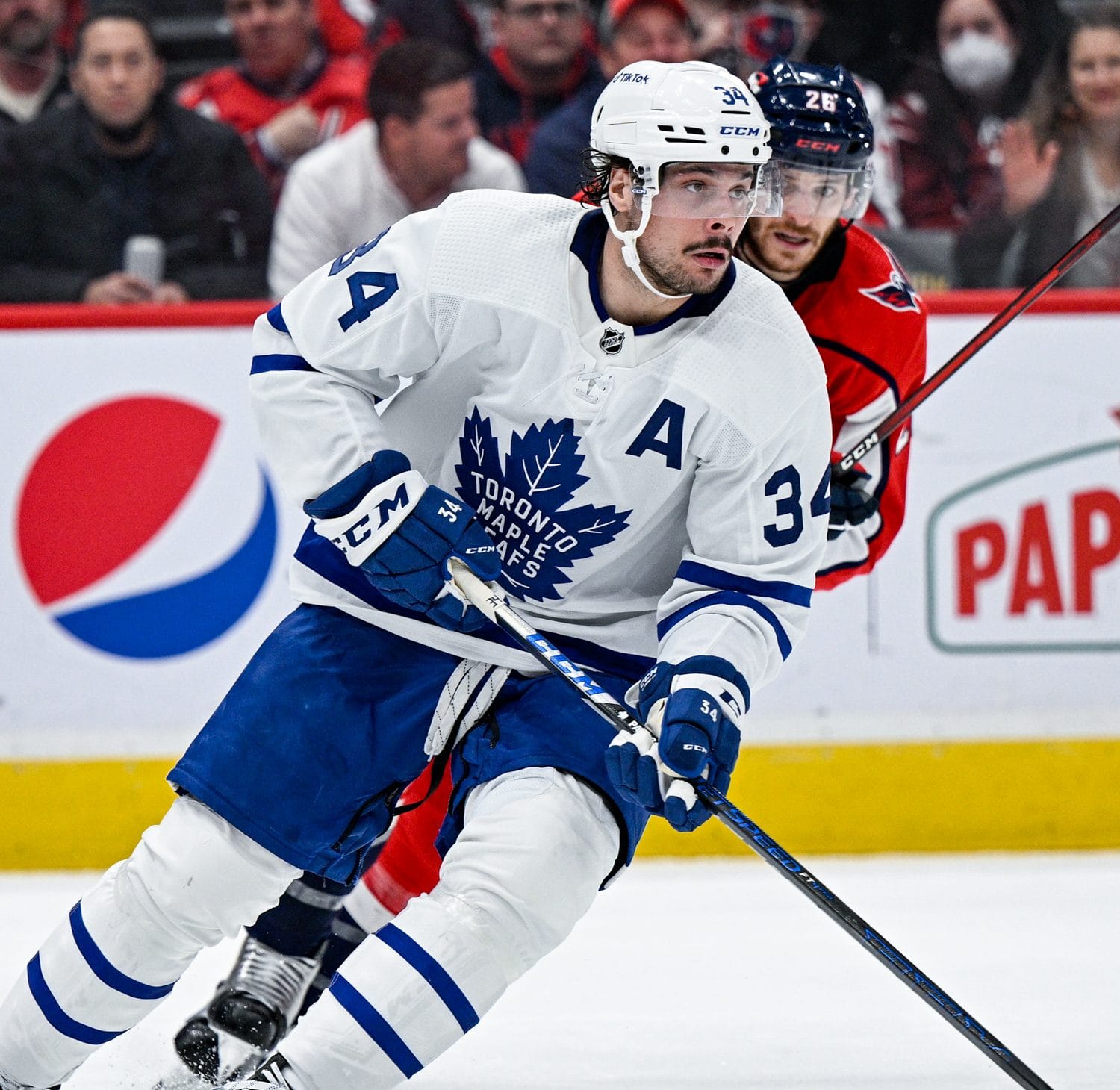 Auston Matthews in the Maple Leafs' white road sweater with the blue leaf crest on the chest, skating with the puck against the Capitals in Washington, February 28, 2022