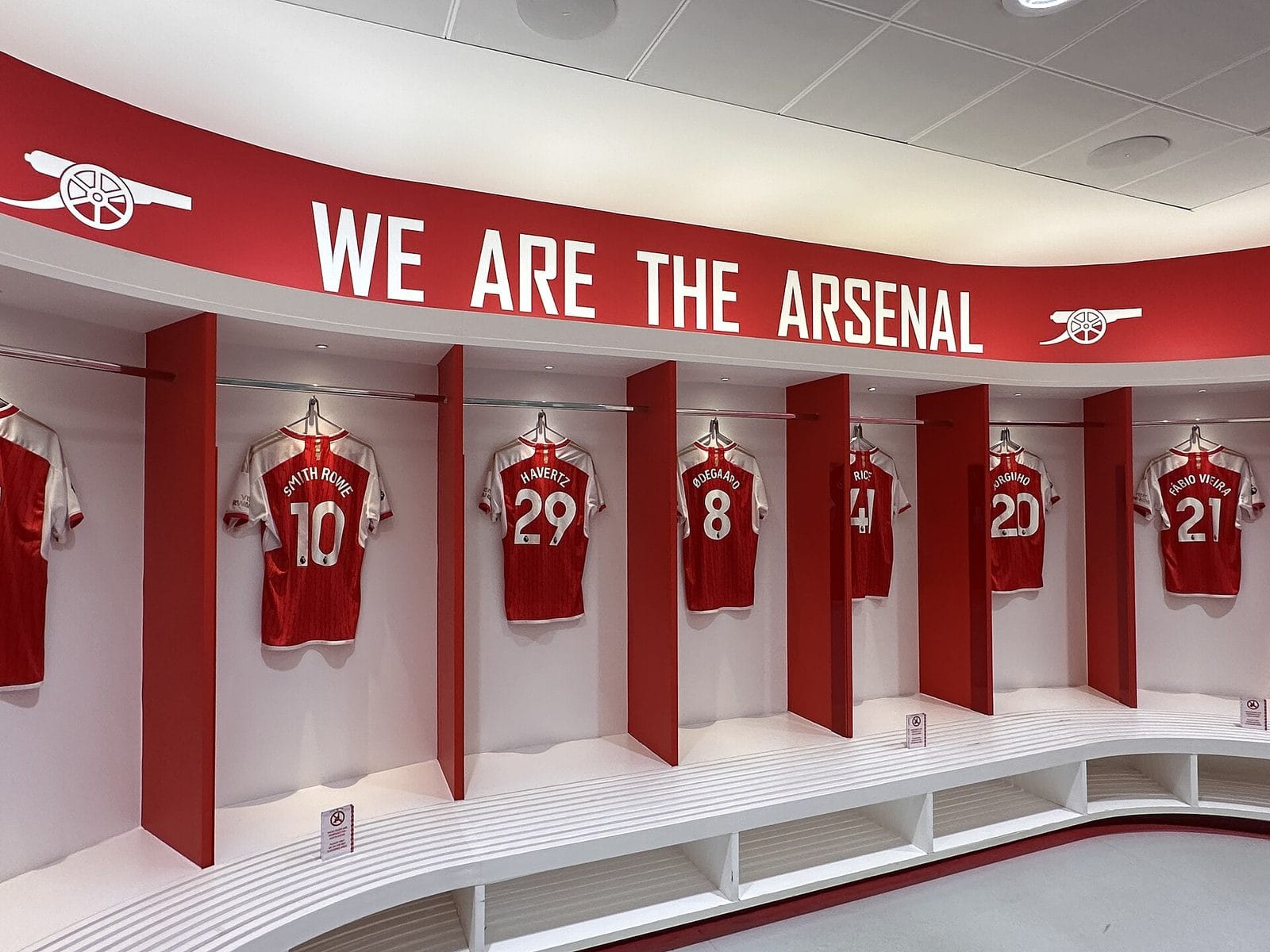 The Arsenal home dressing room at Emirates Stadium, with the club's cannon logo on the wall pointing the same way it does on today's crest