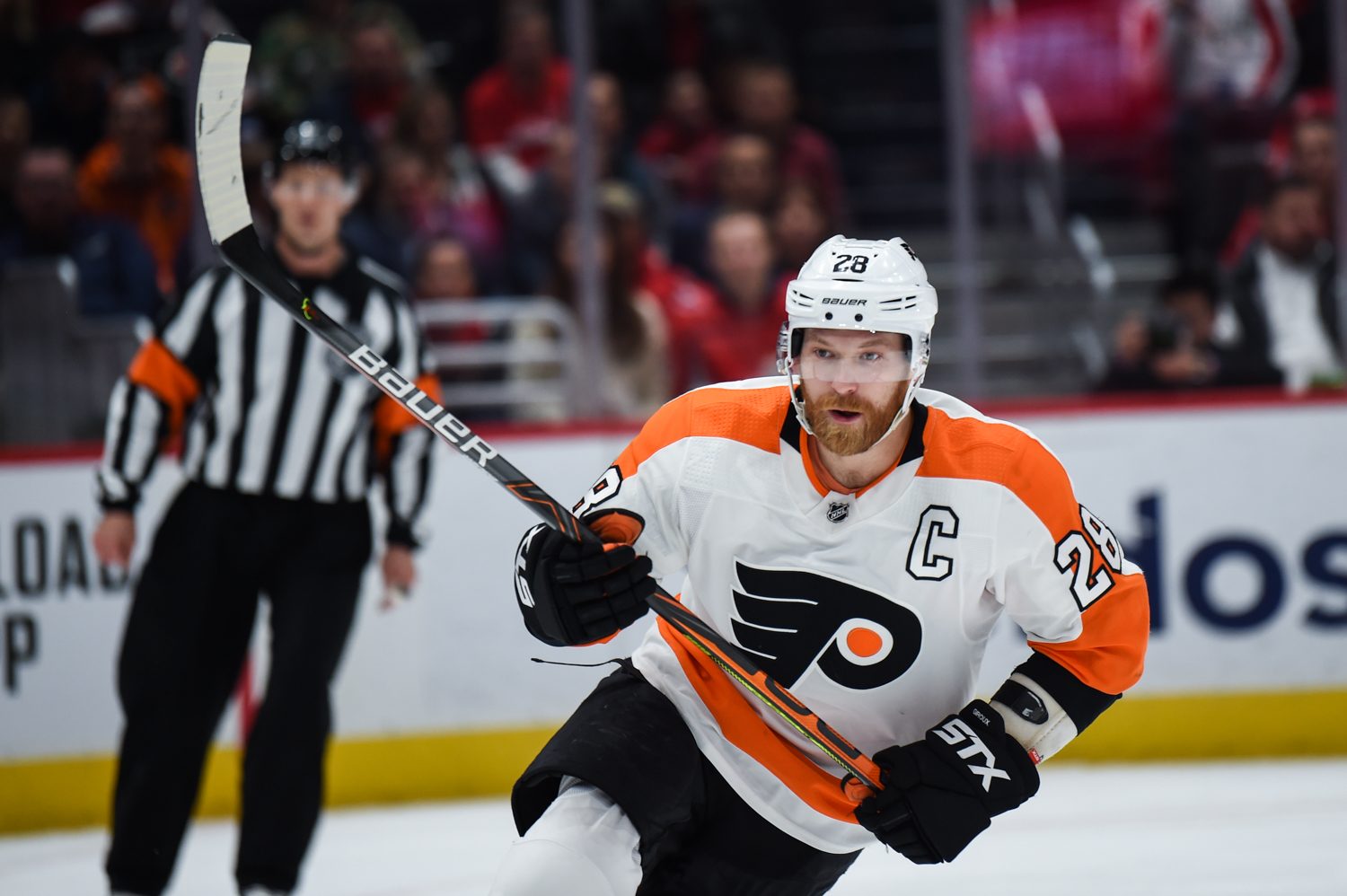 Flyers captain Claude Giroux in the white road jersey, showing the winged P with its orange puck dot, at Capital One Arena