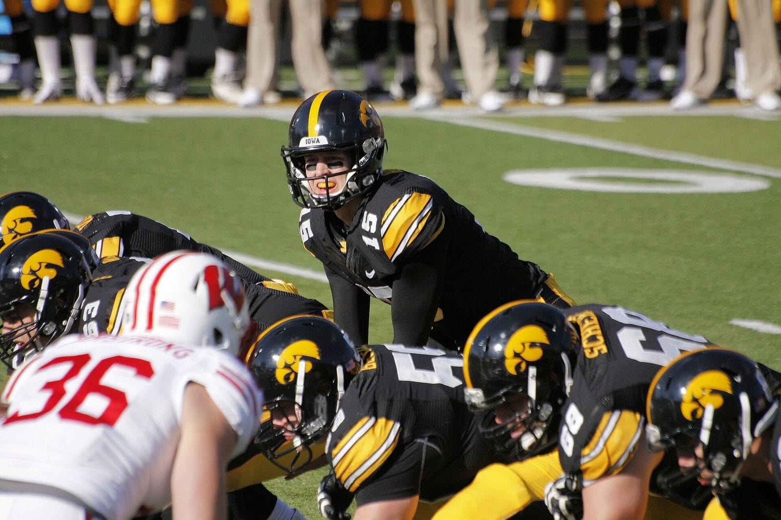 Iowa players at the line in black helmets with the gold Tigerhawk logo, against Wisconsin at Kinnick Stadium on Nov. 2, 2013