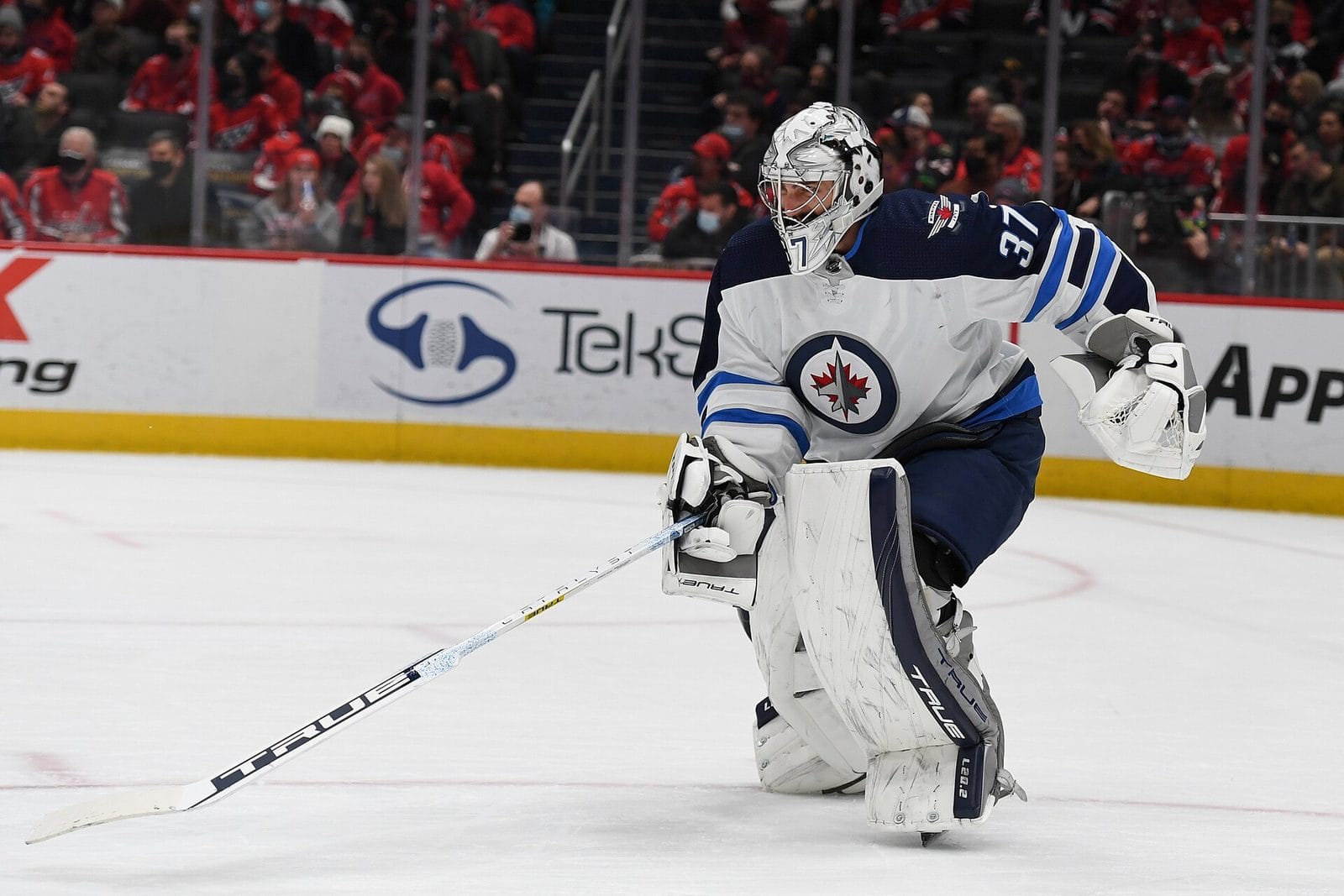 Jets goalie Connor Hellebuyck in the white road jersey with the jet, maple leaf and roundel crest, at Capital One Arena on Jan. 18, 2022