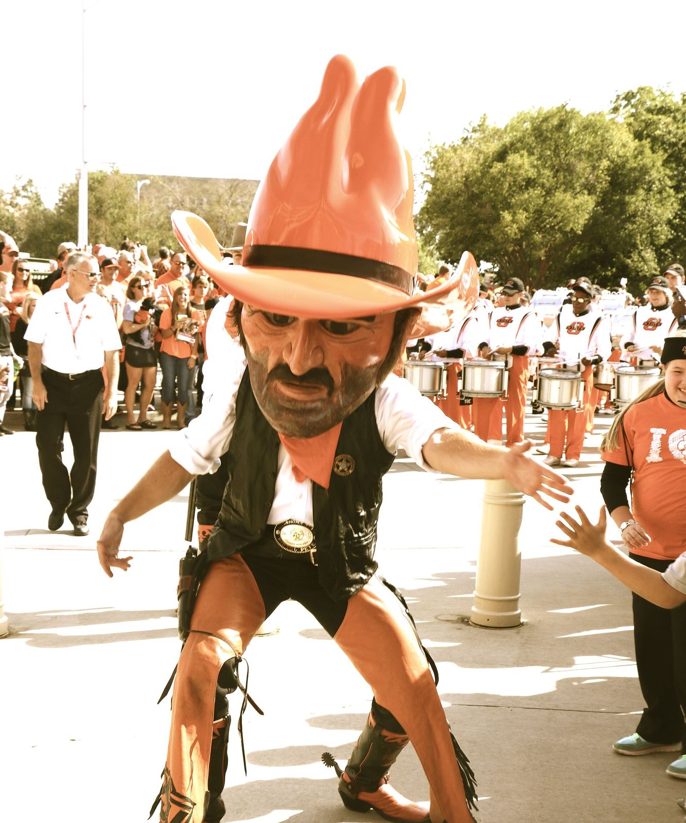 Oklahoma State's Pistol Pete mascot, with the oversized cowboy head, in front of the marching band in 2014