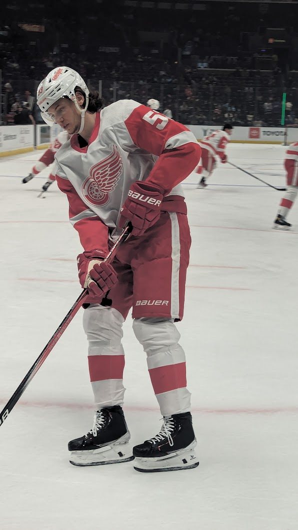 Red Wings defenseman Moritz Seider in warmups in the white road jersey with the red winged wheel crest, in Los Angeles during the 2023-24 season