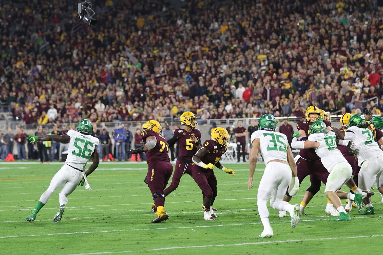 Arizona State quarterback Jayden Daniels drops back in the maroon home jersey and gold helmet against Oregon