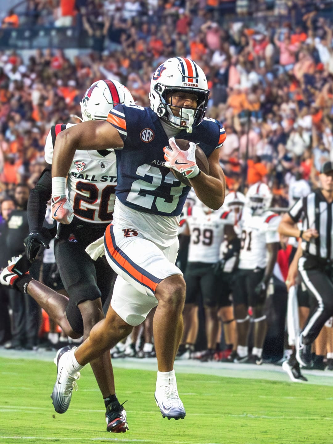 Auburn running back Jeremiah Cobb carries the ball in the navy home jersey, white helmet and white pants at Jordan-Hare Stadium