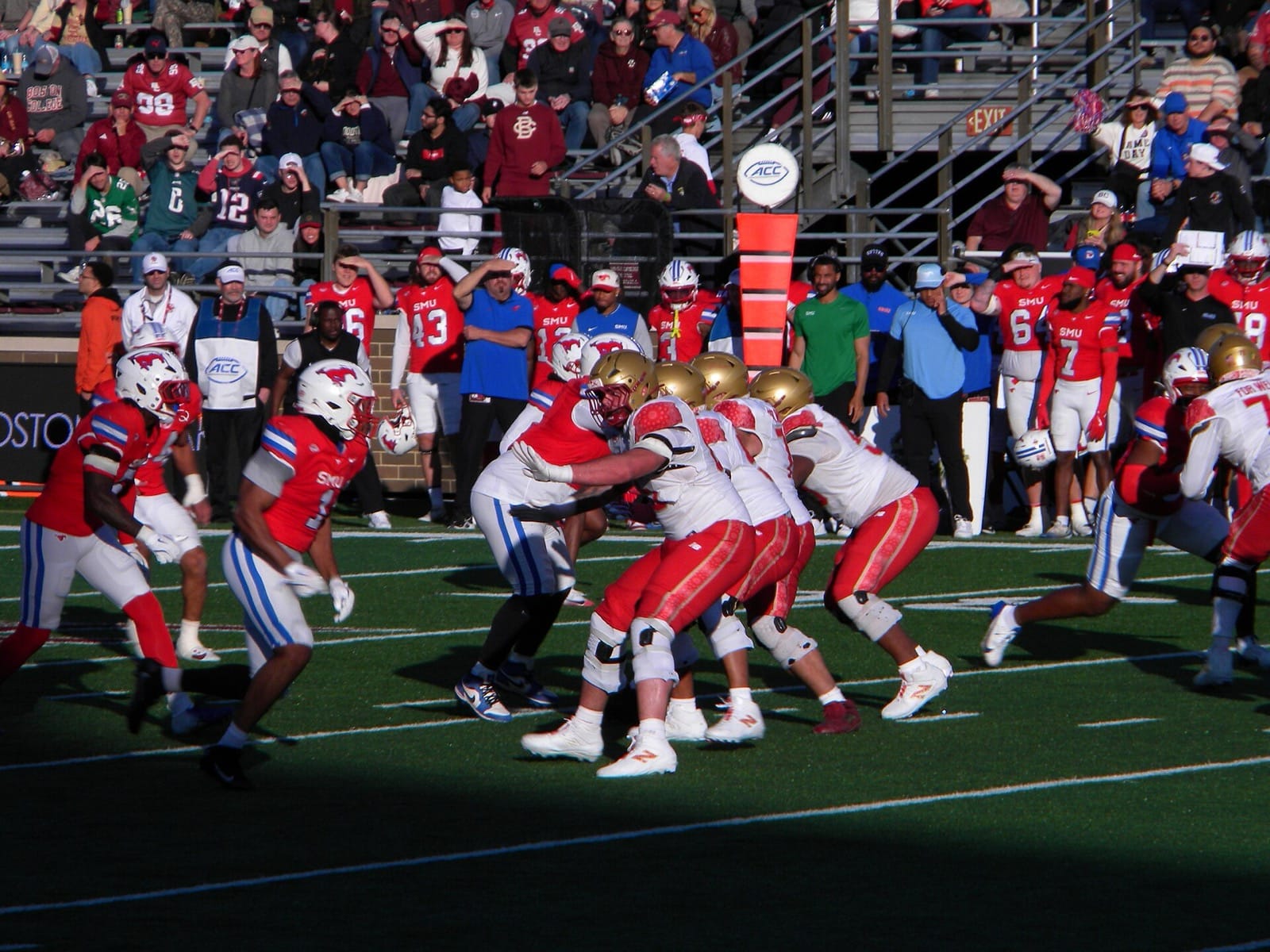 Boston College quarterback drops back in a white jersey and gold helmet against SMU in November 2025
