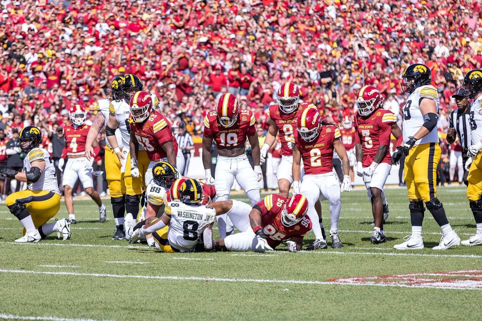 Iowa State players in cardinal jerseys and cardinal helmets during the Cy-Hawk game at Jack Trice Stadium