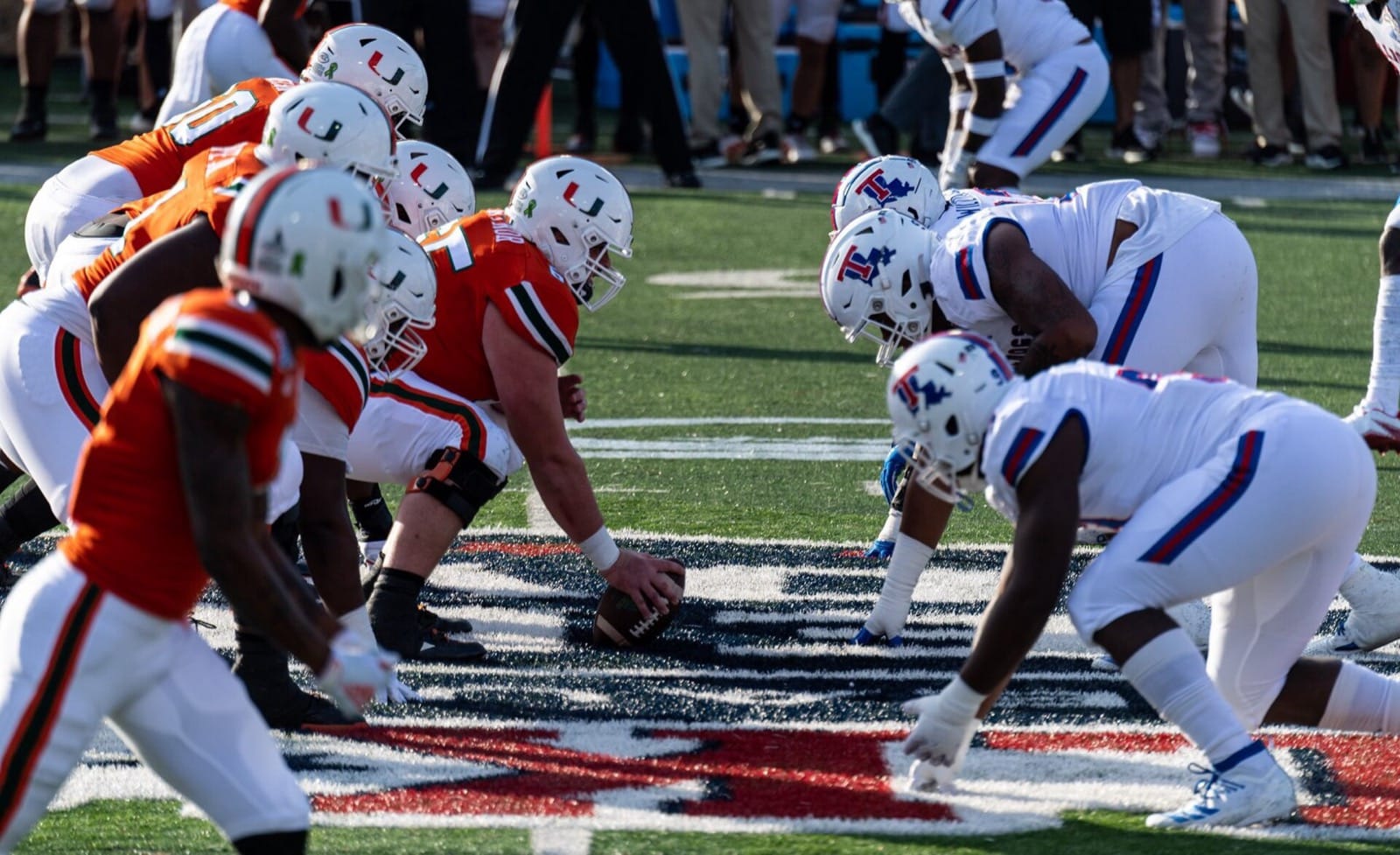 Miami in orange jerseys and white helmets lines up against Louisiana Tech at the 2019 Independence Bowl
