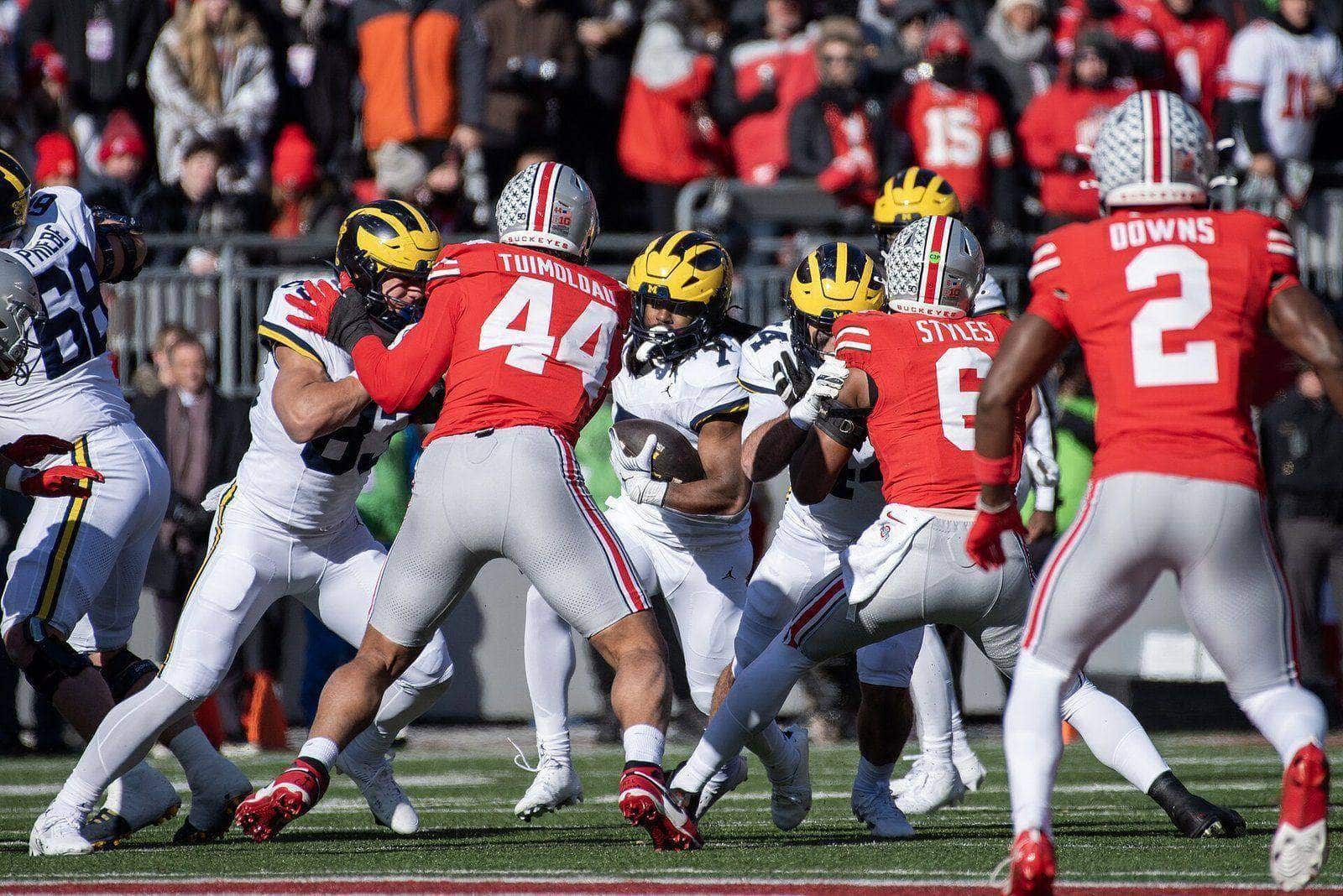 Ohio State players in scarlet home jerseys, gray pants and silver helmets against Michigan at Ohio Stadium