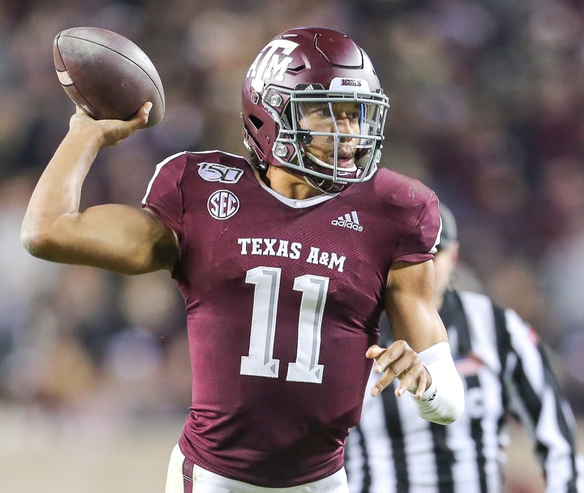 Texas A&M quarterback Kellen Mond throws in the maroon home jersey and maroon helmet at Kyle Field