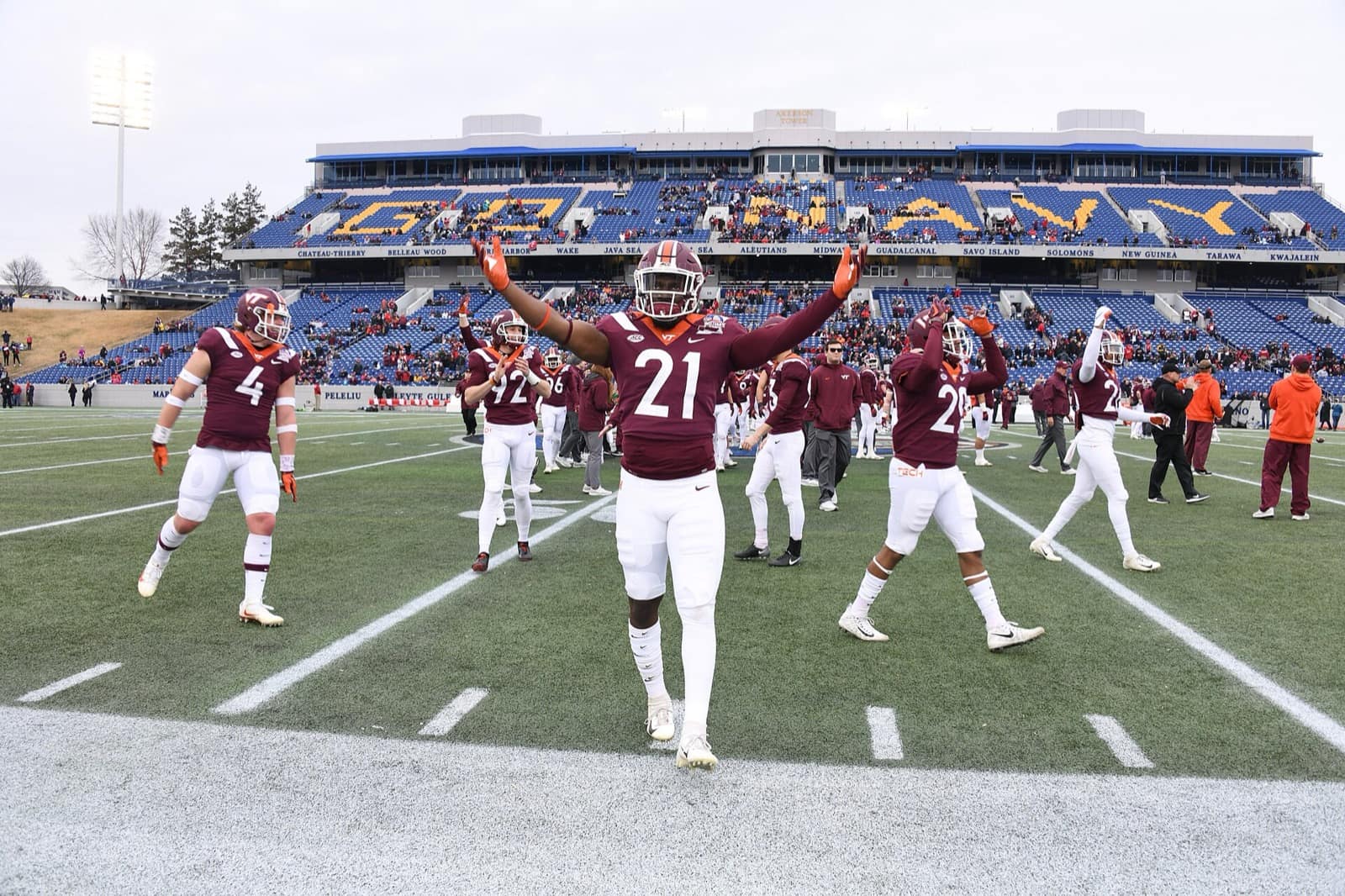 Virginia Tech players in maroon jerseys pump up the crowd before the 2018 Military Bowl