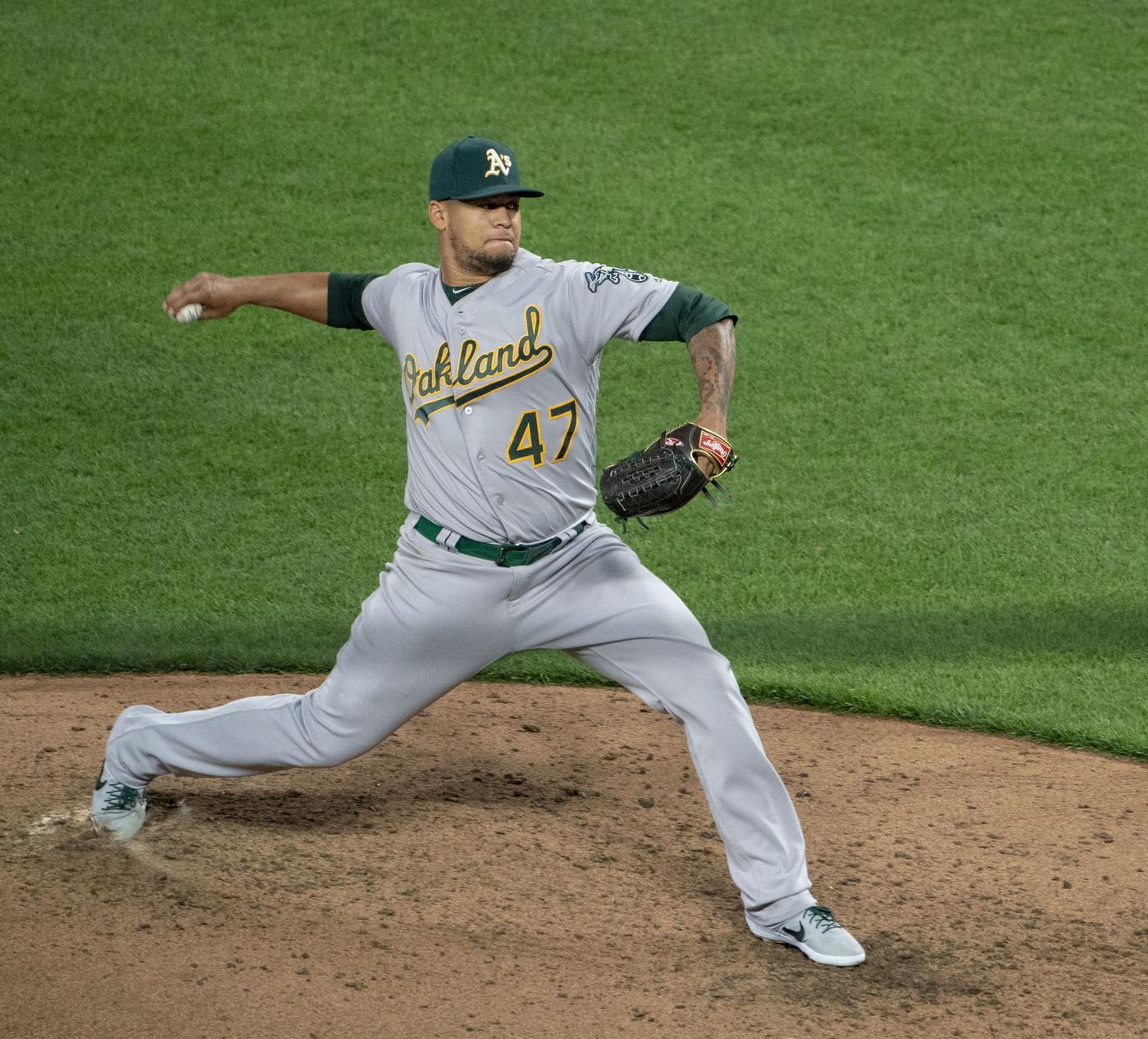 Frankie Montas pitches in the Athletics' gray road uniform with green and gold Oakland script