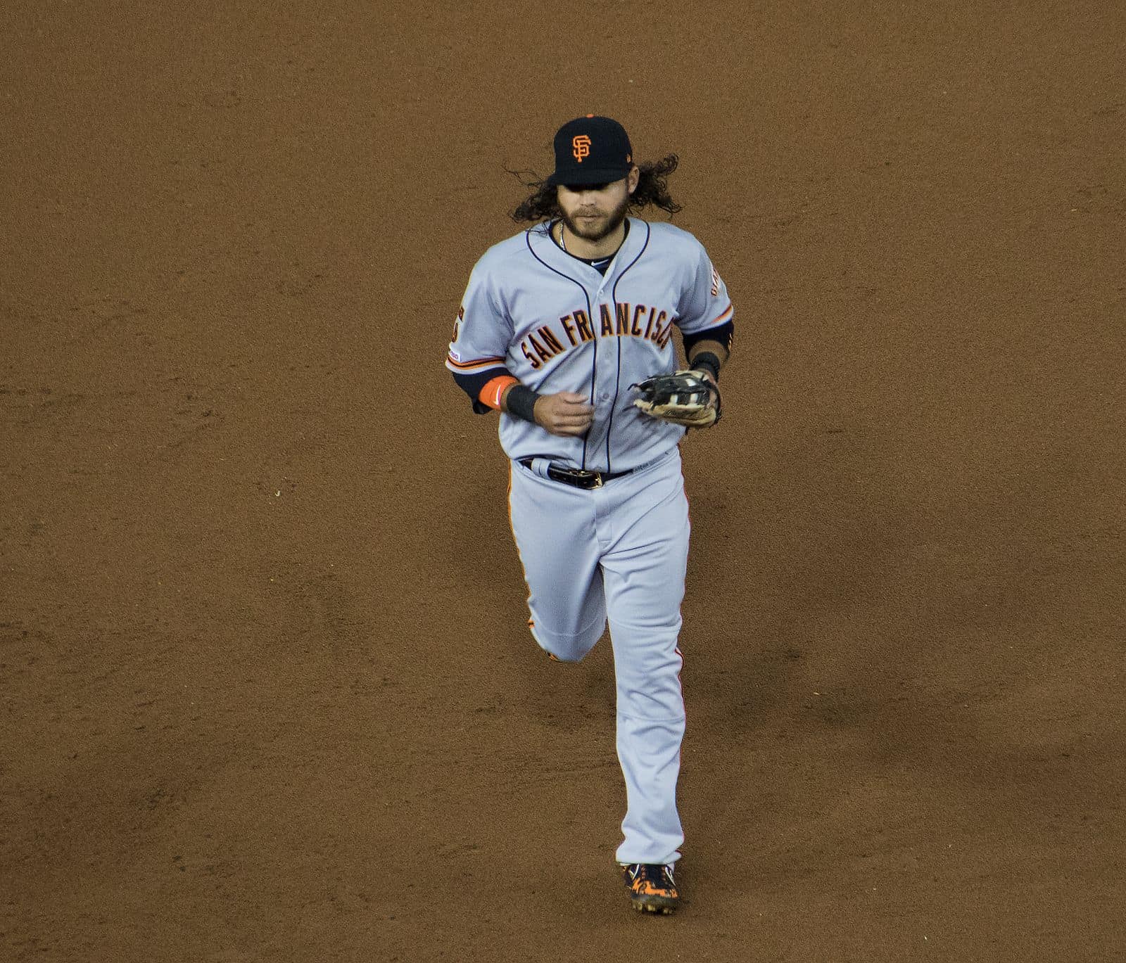Brandon Crawford jogs in wearing the Giants' road gray San Francisco uniform and black cap