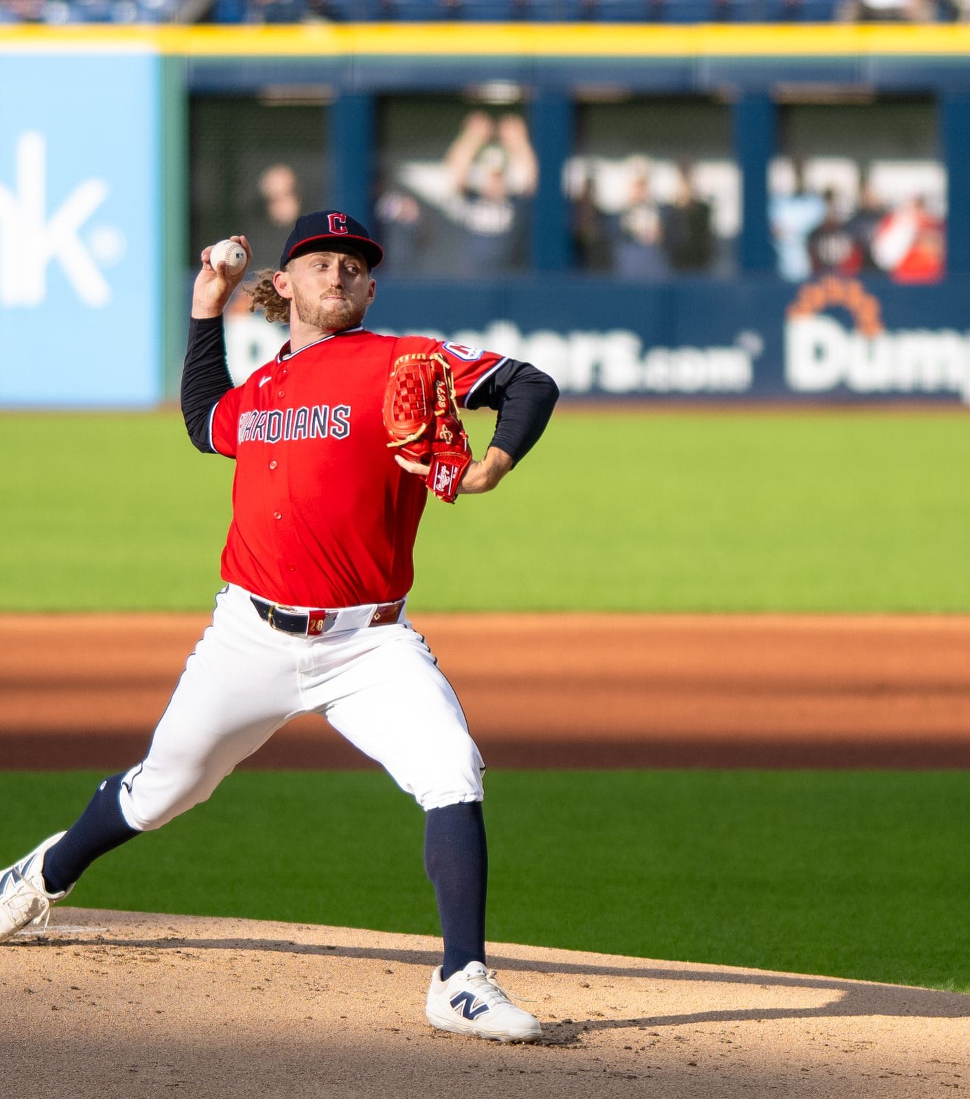 Tanner Bibee delivers a pitch in the Guardians' red jersey with navy Guardians lettering and a navy C cap