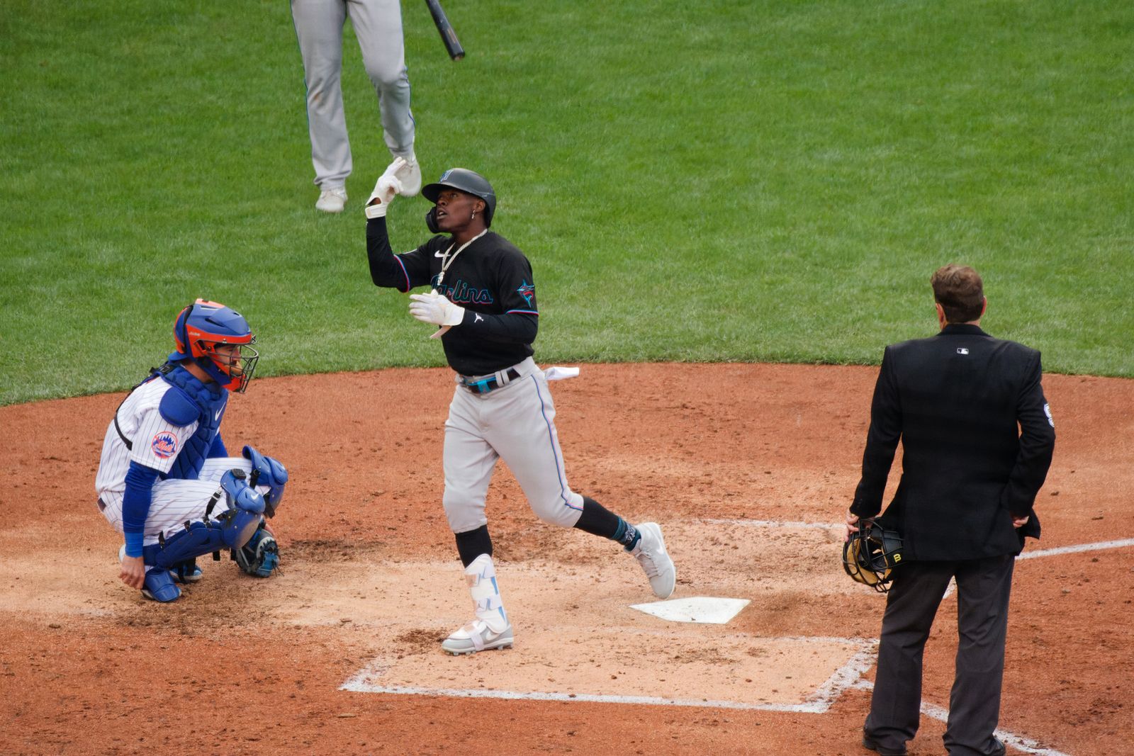 Jazz Chisholm Jr. after touching home plate in the Marlins' black alternate jersey and gray pants