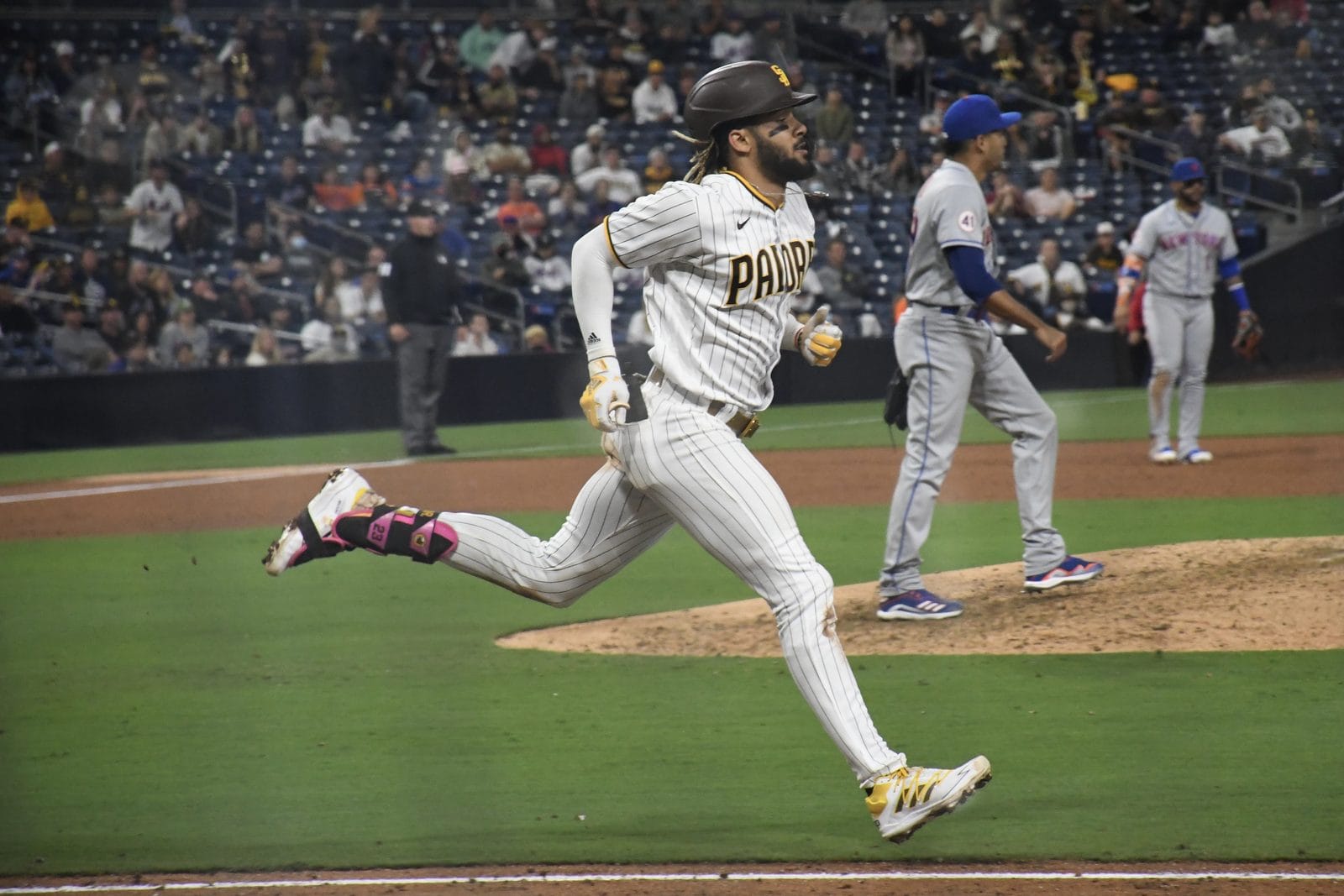 Fernando Tatis Jr. runs out a ground ball in the Padres' brown and gold home pinstripes