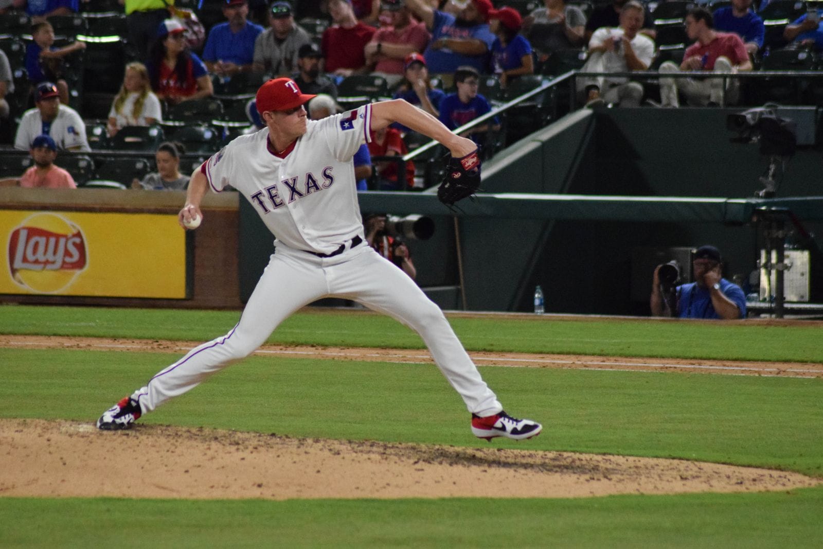 Peter Fairbanks pitches in the Rangers' white home uniform with TEXAS lettering and a red T cap