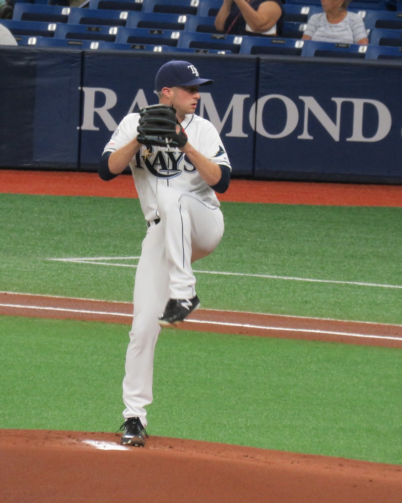 Trevor Richards in his leg kick in the Rays' white home uniform with navy Rays script and a TB cap