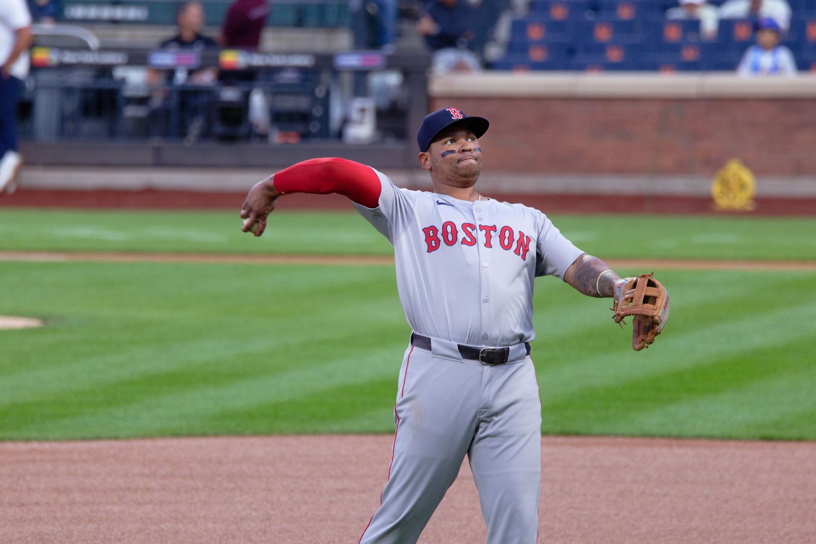 Rafael Devers throws during warmups in the Red Sox gray road uniform with red BOSTON lettering