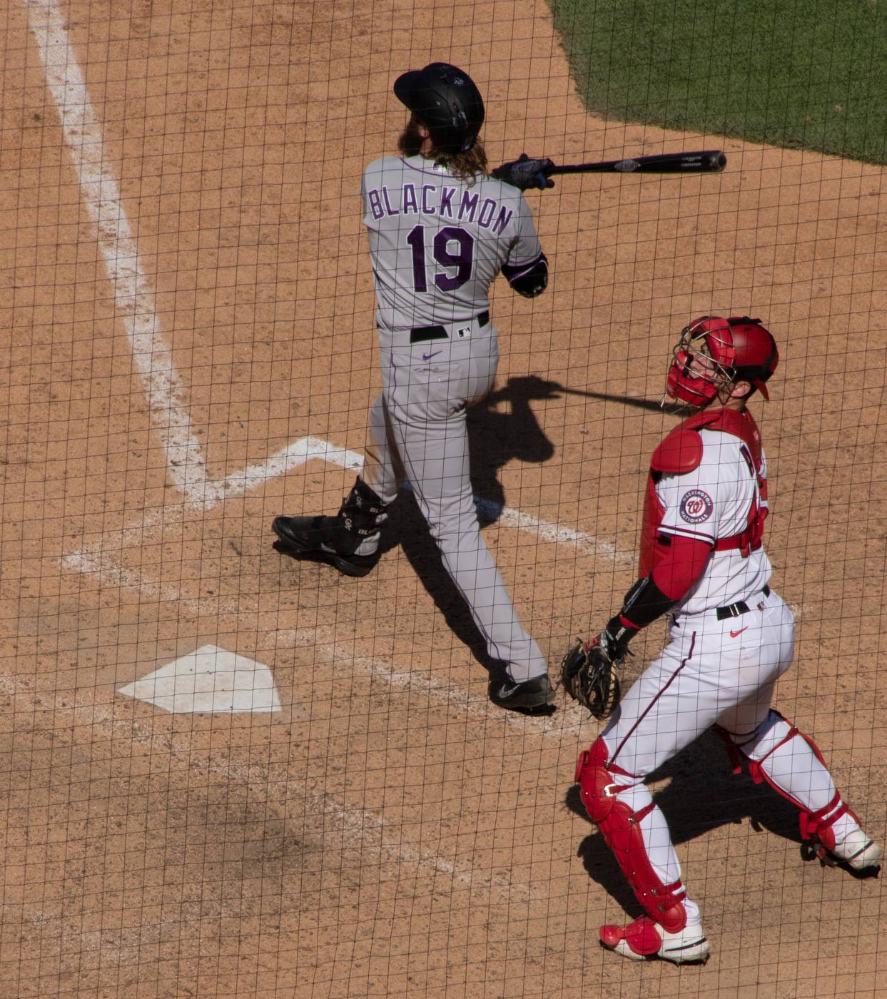Charlie Blackmon swings in the Rockies' road gray uniform with purple lettering
