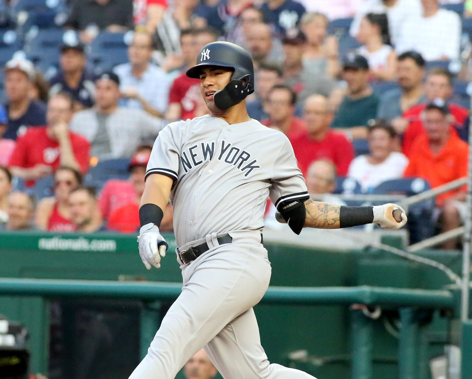 Gleyber Torres follows through on a swing in the Yankees' gray road uniform with NEW YORK across the chest