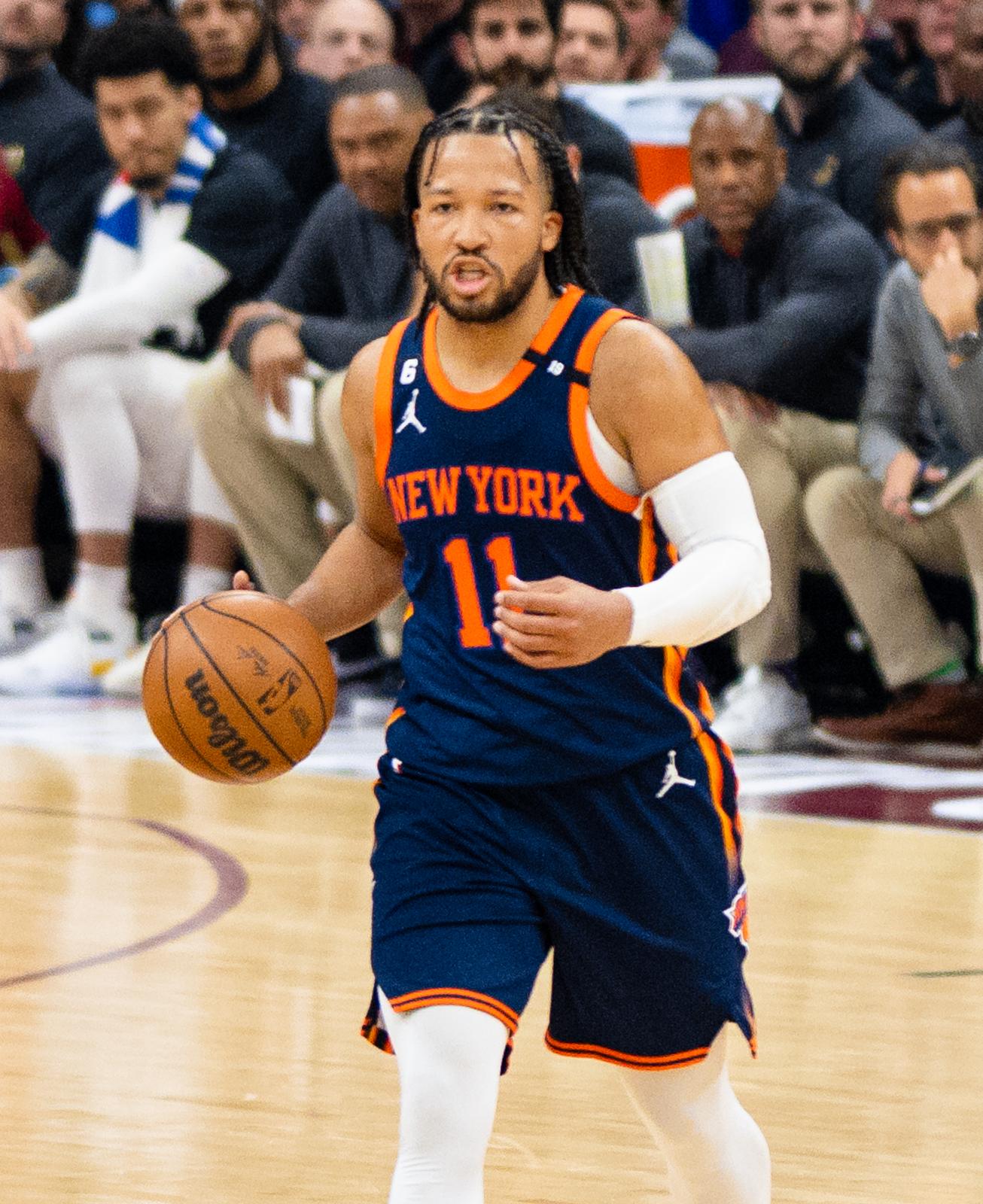 Jalen Brunson dribbles in the Knicks' navy road uniform, NEW YORK in orange over No. 11, in Cleveland during the 2023 playoffs