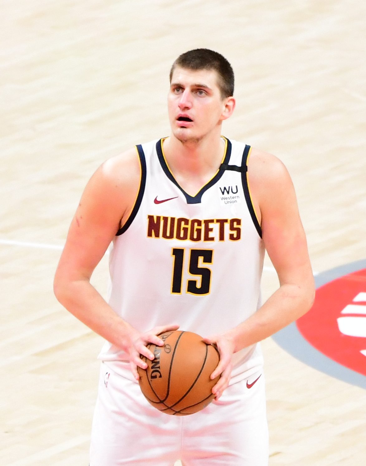 Nikola Jokic holds the ball at the free-throw line in the Nuggets' white uniform, NUGGETS over No. 15, at Capital One Arena, January 4, 2020
