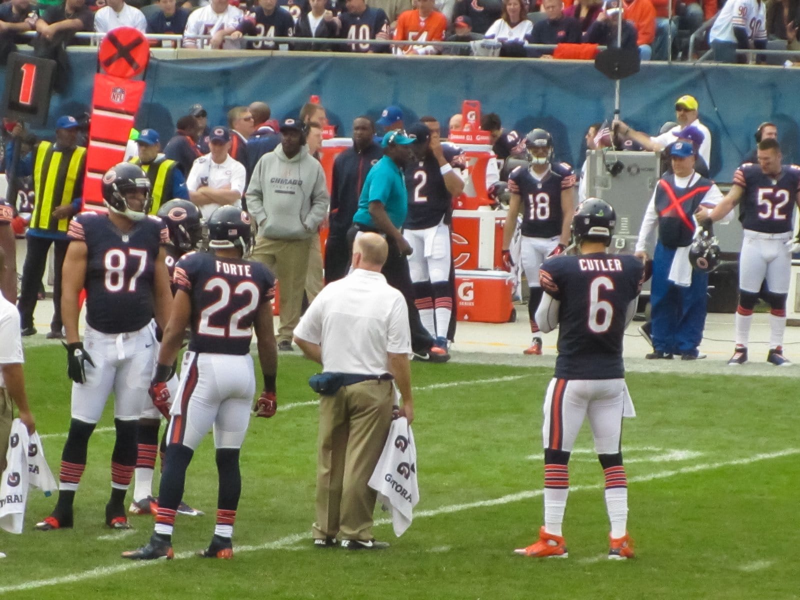 Bears offense, including Jay Cutler and Matt Forte, in navy home jerseys with orange-and-white sleeve stripes, white pants and navy helmets, during a TV timeout against the Seahawks at Soldier Field in December 2012