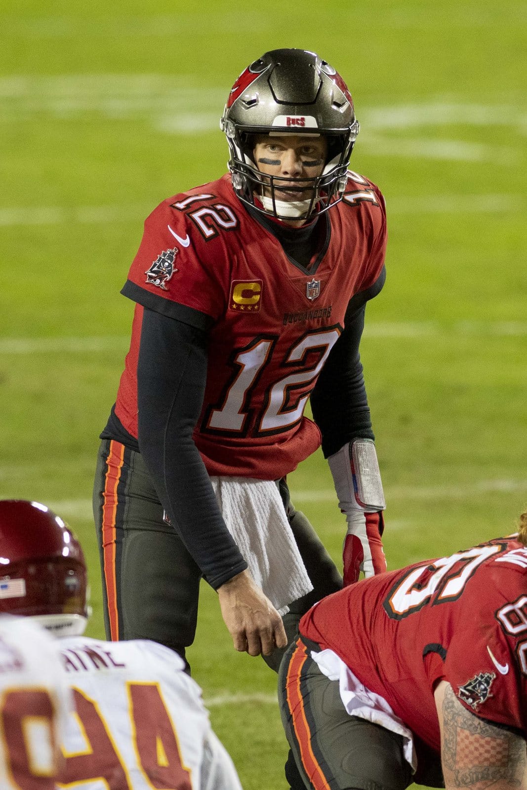 Buccaneers quarterback Tom Brady in the red jersey, pewter pants and pewter helmet with the red skull-and-swords flag, at the line against Washington in the NFC Wild Card game at FedExField on Jan. 9, 2021