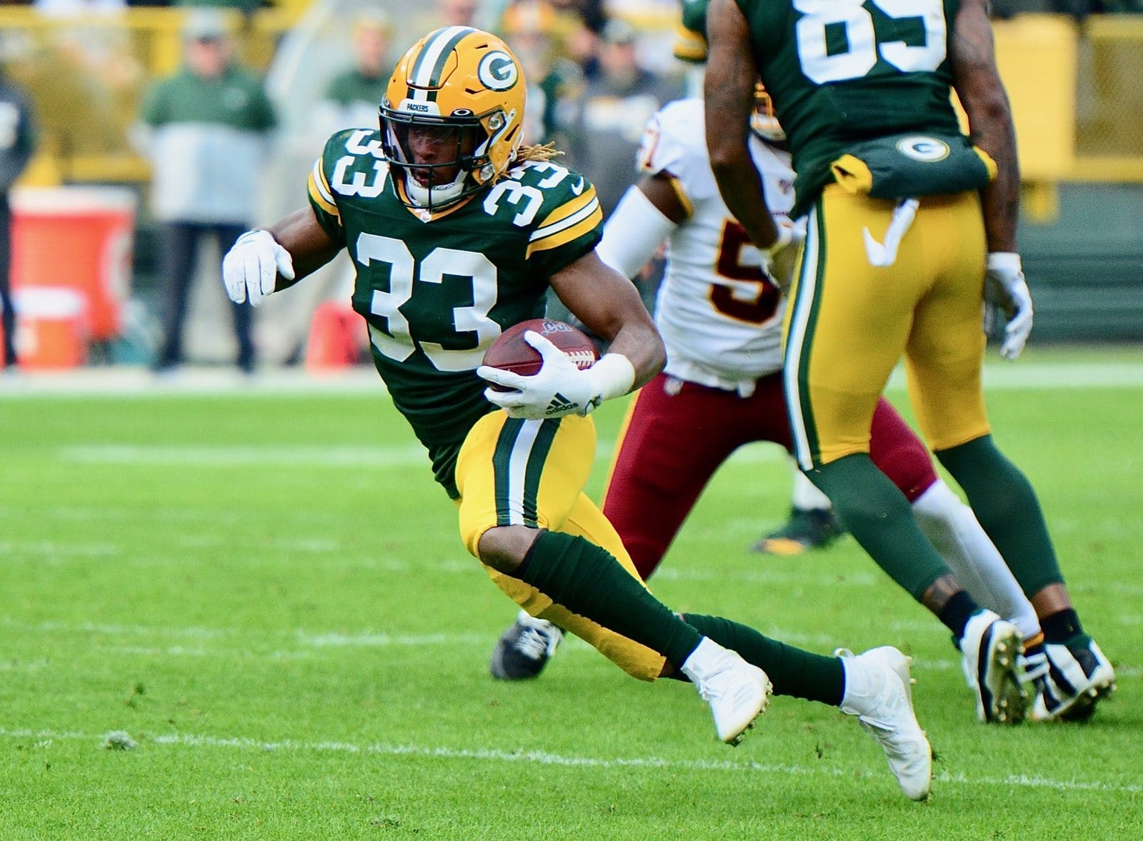 Packers running back Aaron Jones runs in the dark green home jersey, gold pants and gold helmet against Washington at Lambeau Field in Green Bay on Dec. 8, 2019