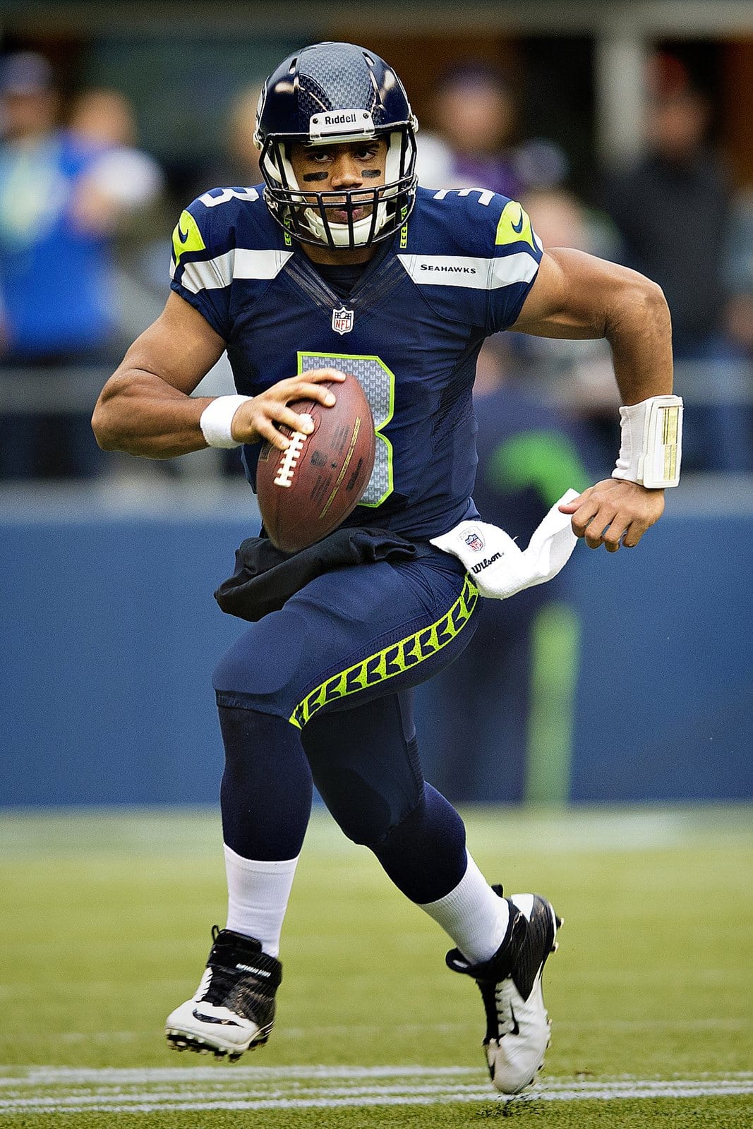 Seahawks quarterback Russell Wilson scrambles in the College Navy home jersey with Action Green trim, navy pants and navy helmet, against the Vikings at CenturyLink Field in Seattle on Nov. 4, 2012