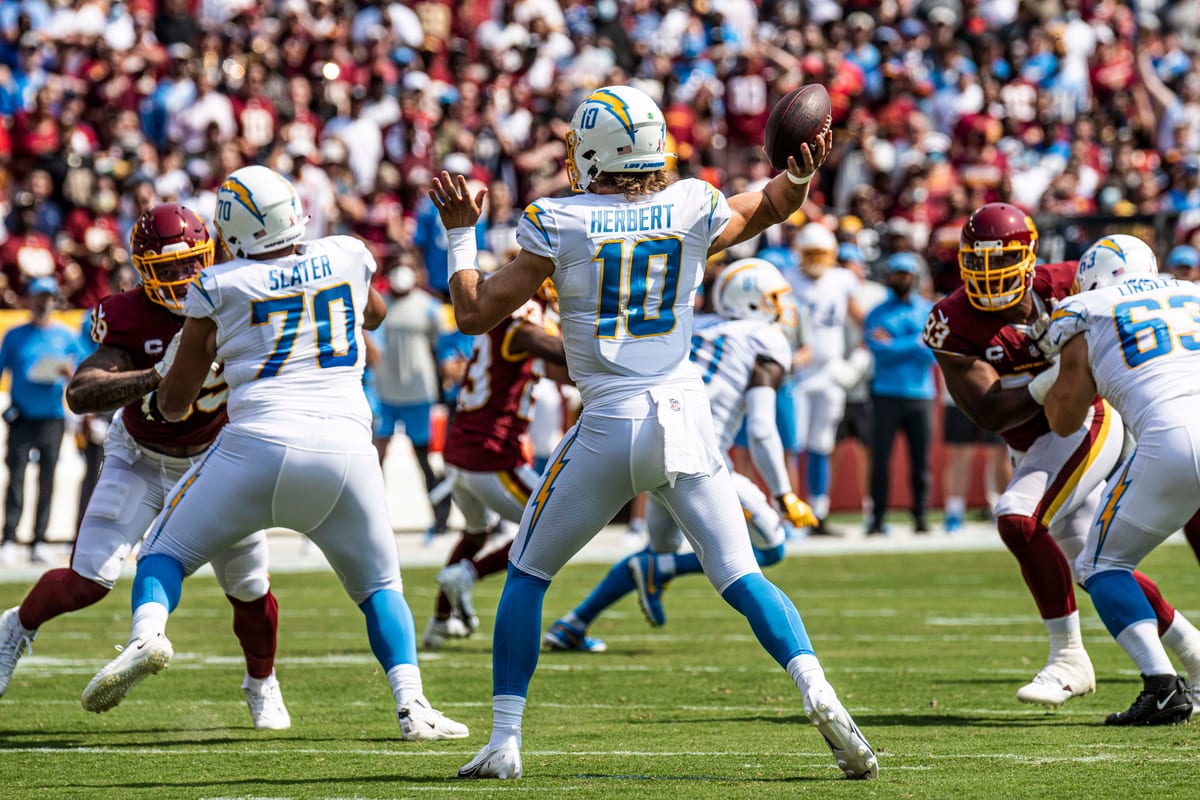 Chargers quarterback Justin Herbert throws a pass in the powder blue and white road uniform against Washington in 2021